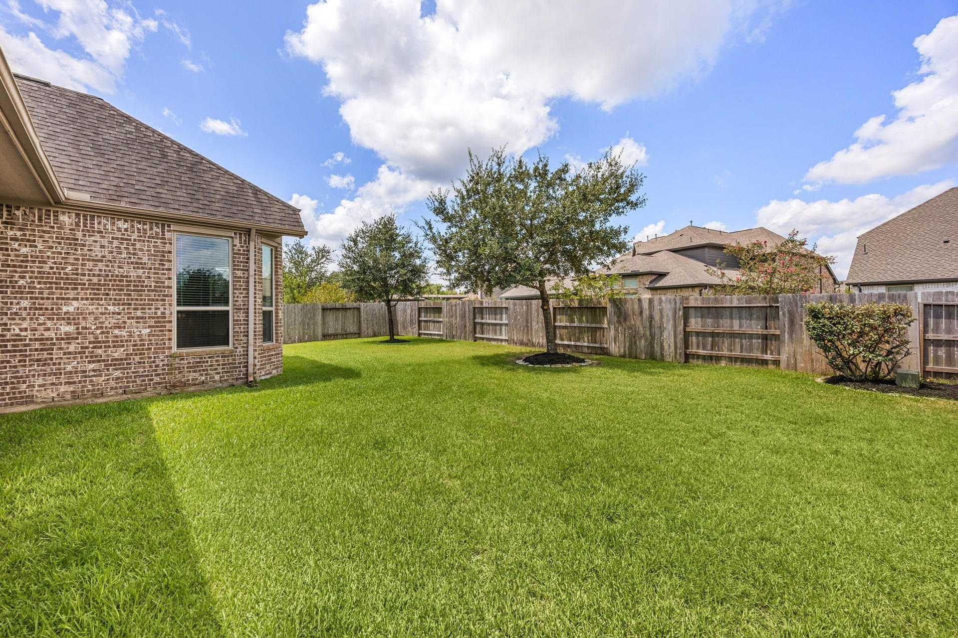13522 Columbia Key Drive, Tomball, TX 77377 Viewed from the patio, the spacious backyard offers plenty of room to play, gather, or simply enjoy the outdoor space as it is.