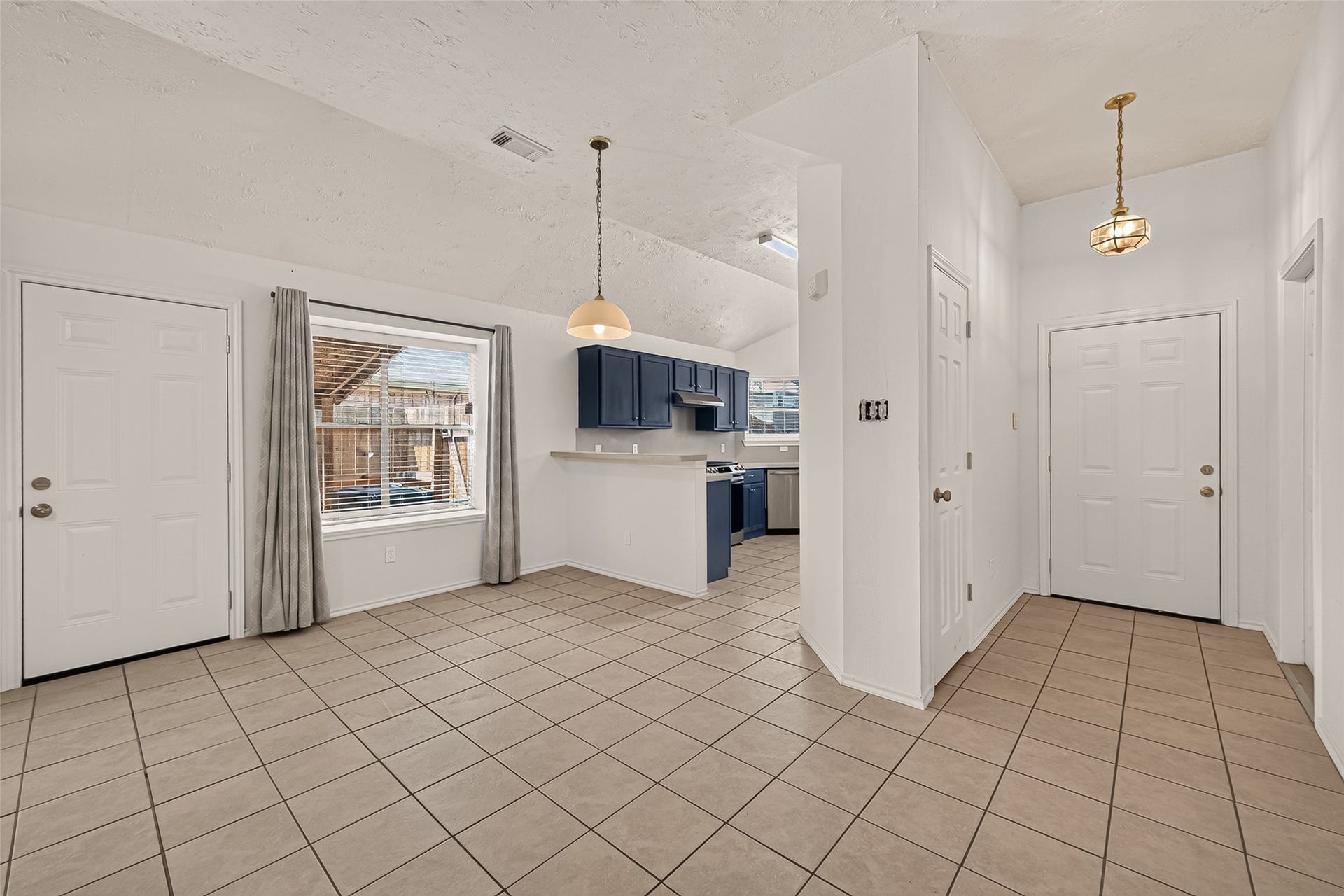 3356 Rachel Lane, Katy, TX 77493 A view of the kitchen from the north wall of the living room. Front door is seen and the entry closet. Covered back patio visible from this window.