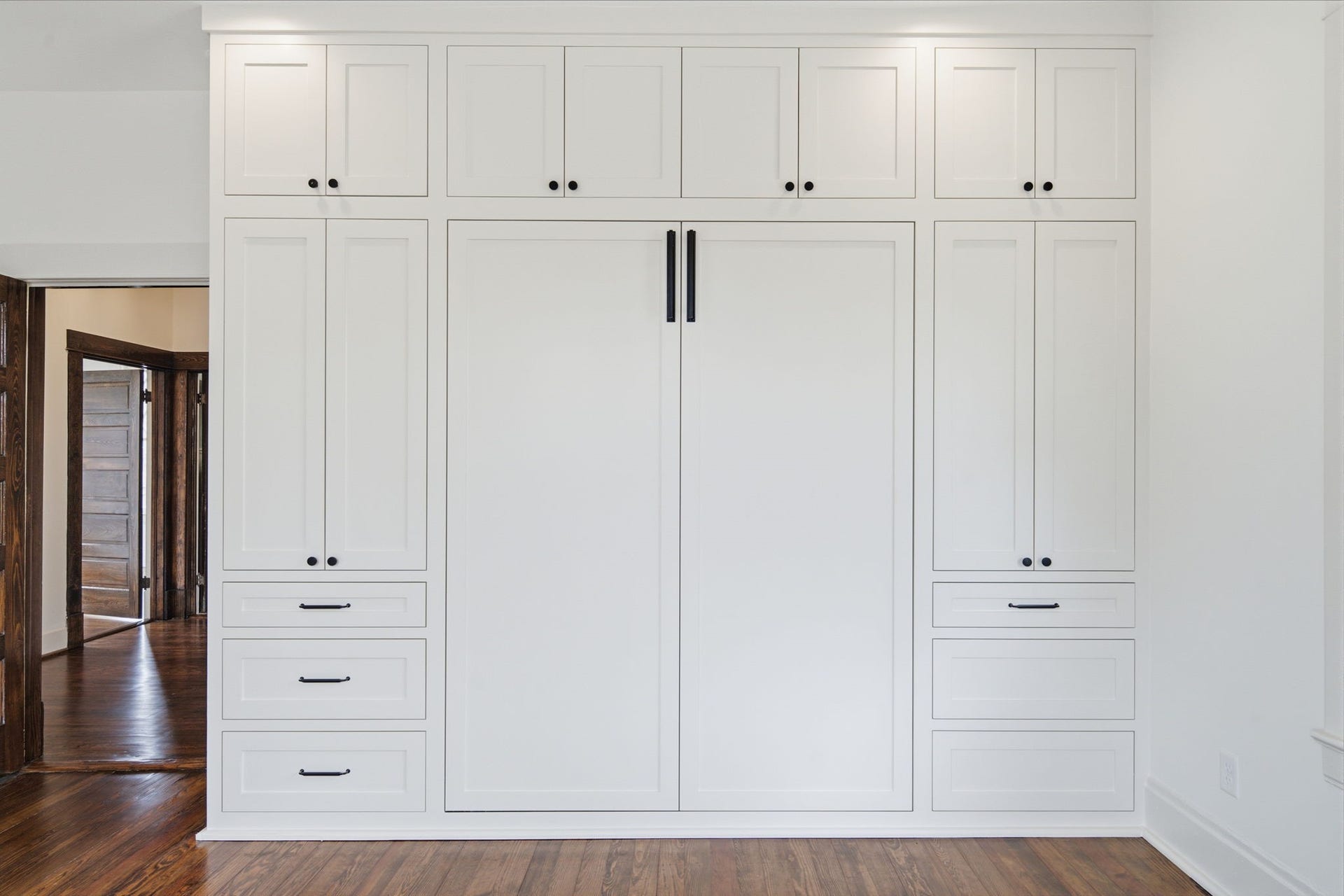 404 Avondale Street, Houston, TX 77006 Built-in Murphy bed and cabinetry offers ample storage with sleek white finishes and contrasting black hardware.