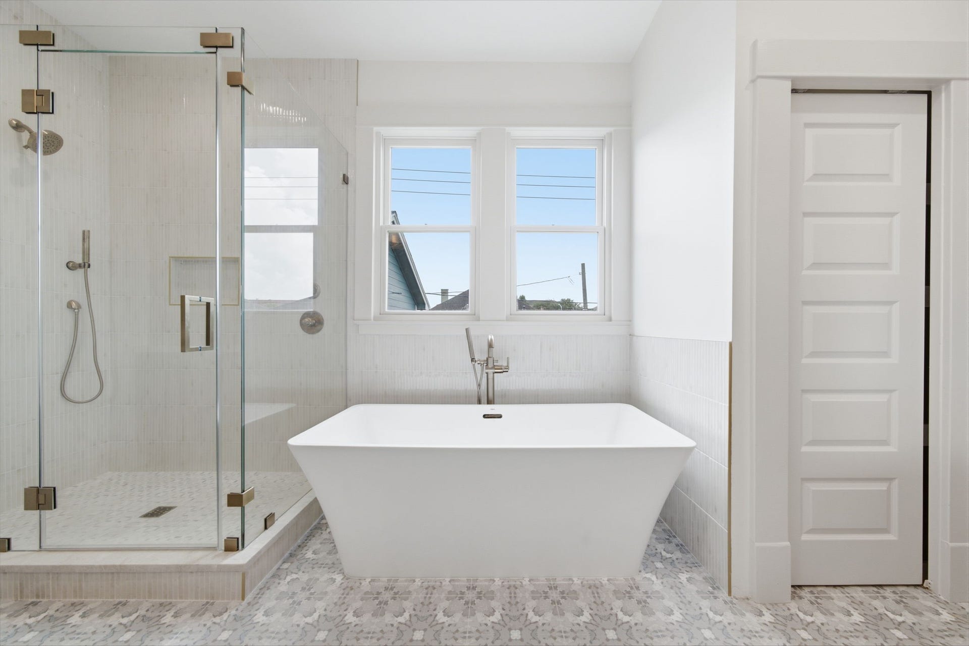 404 Avondale Street, Houston, TX 77006 The primary bathroom featuring a spacious glass-enclosed shower and a luxurious 67 inch freestanding bathtub, accented by natural light.