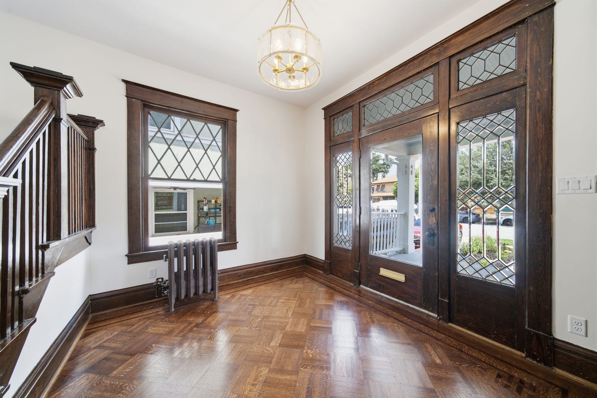 404 Avondale Street, Houston, TX 77006 Entryway featuring rich woodwork, elegant leaded glass windows, and a classic chandelier, offering a warm welcome with its timeless character and natural light.