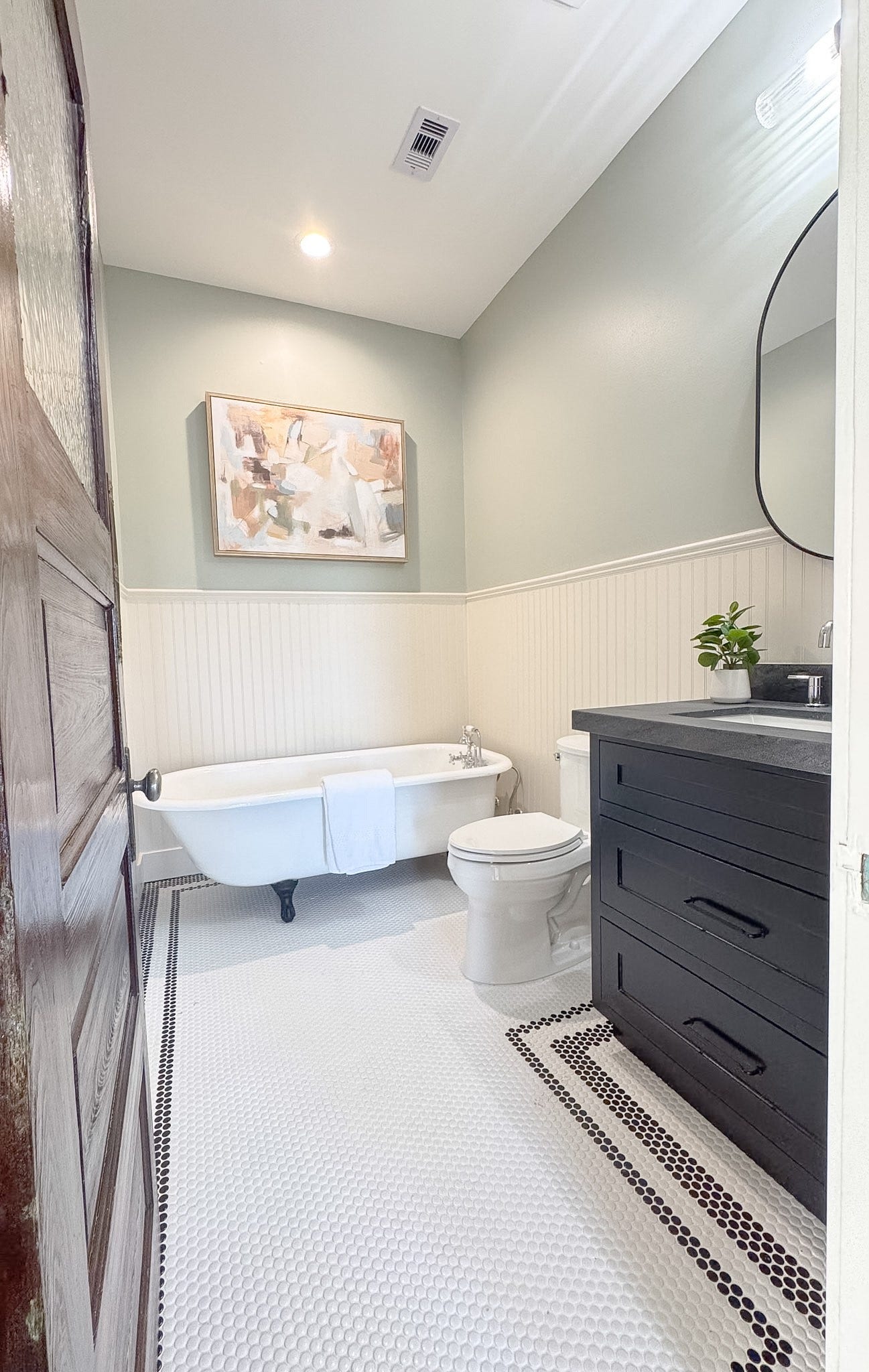 404 Avondale Street, Houston, TX 77006 The original upstairs bathroom includes the original clawfoot tub, single vanity with sleek fixtures, and tasteful wainscoting for a timeless touch.