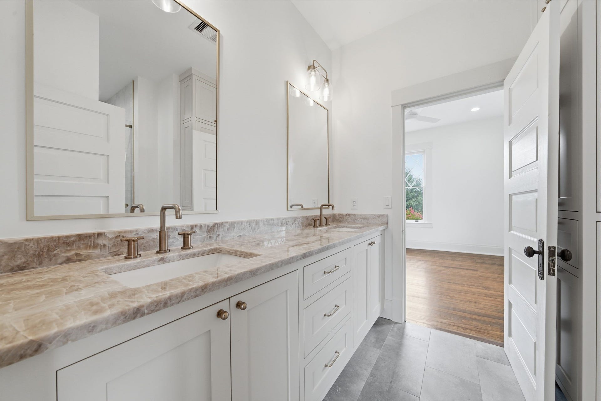 404 Avondale Street, Houston, TX 77006 Jack and Jill bath between two of the upstairs bed rooms. One of three bathrooms upstairs. This bathroom featuring a dual-sink vanity with a quartz countertop and Delta fixtures.