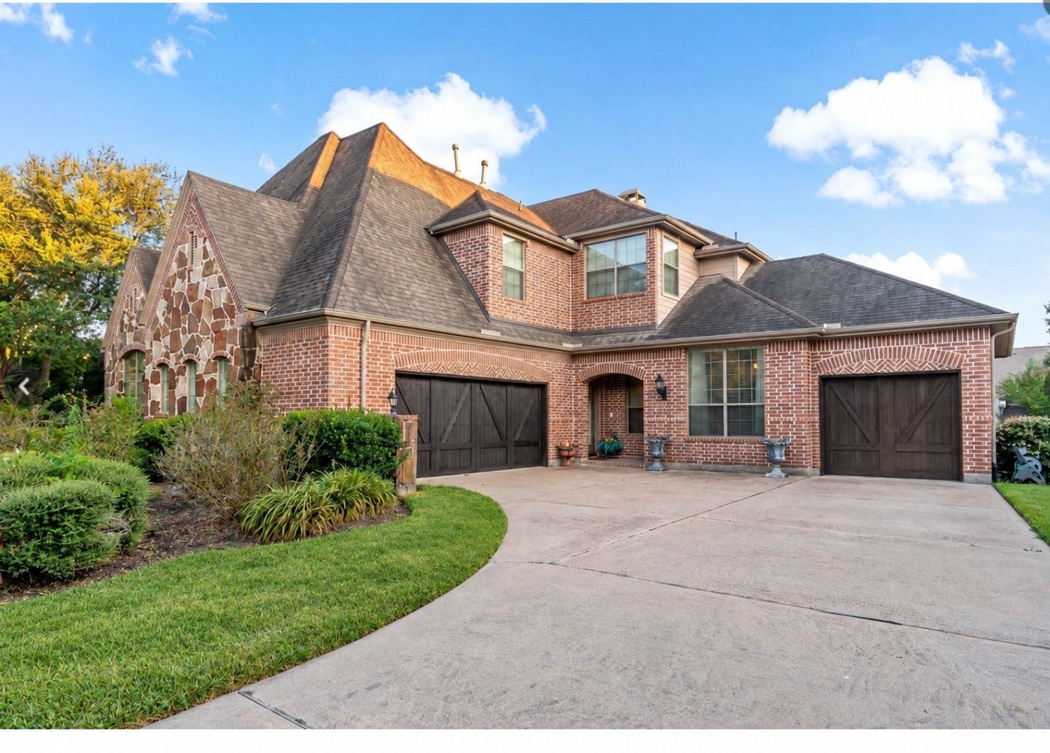 22 Waters Lake Boulevard, Missouri City, TX 77459 Charming brick home with a spacious driveway and two-car garage, featuring a beautifully landscaped front yard and elegant stone detailing.