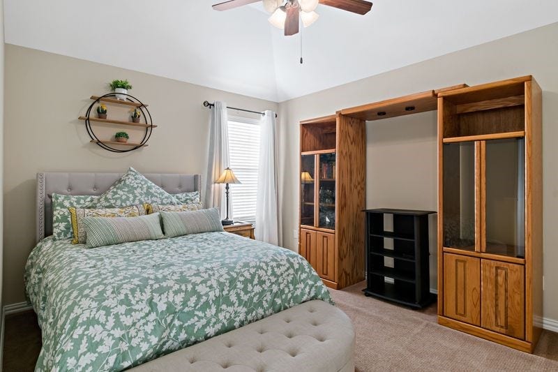 22 Waters Lake Boulevard, Missouri City, TX 77459 Cozy bedroom with a stylish bed, elegant shelving, and abundant natural light.