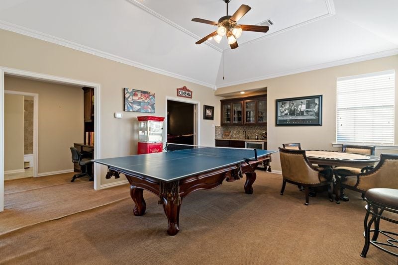 22 Waters Lake Boulevard, Missouri City, TX 77459 Spacious entertainment room featuring a ping pong table, wet bar, and cozy seating area, perfect for gatherings and leisure activities.
