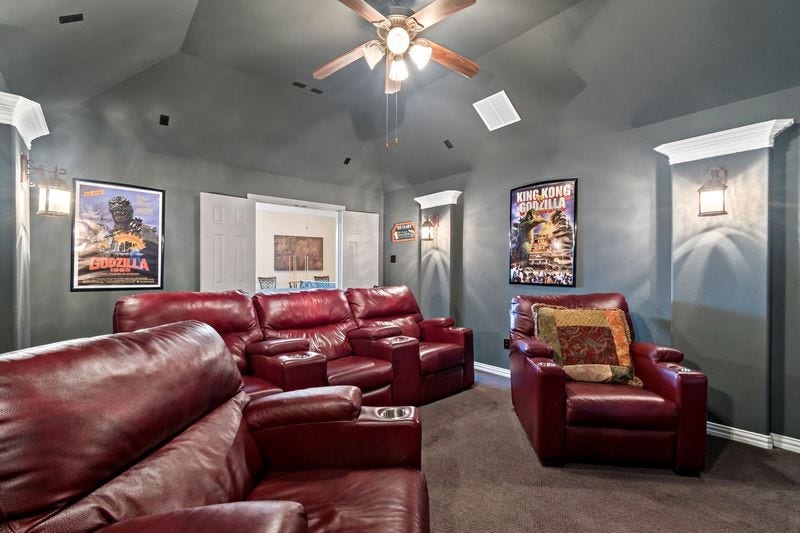 22 Waters Lake Boulevard, Missouri City, TX 77459 Experience cinematic comfort in this inviting home theater, featuring plush red leather recliners, atmospheric lighting, and a cozy ambiance perfect for movie nights.