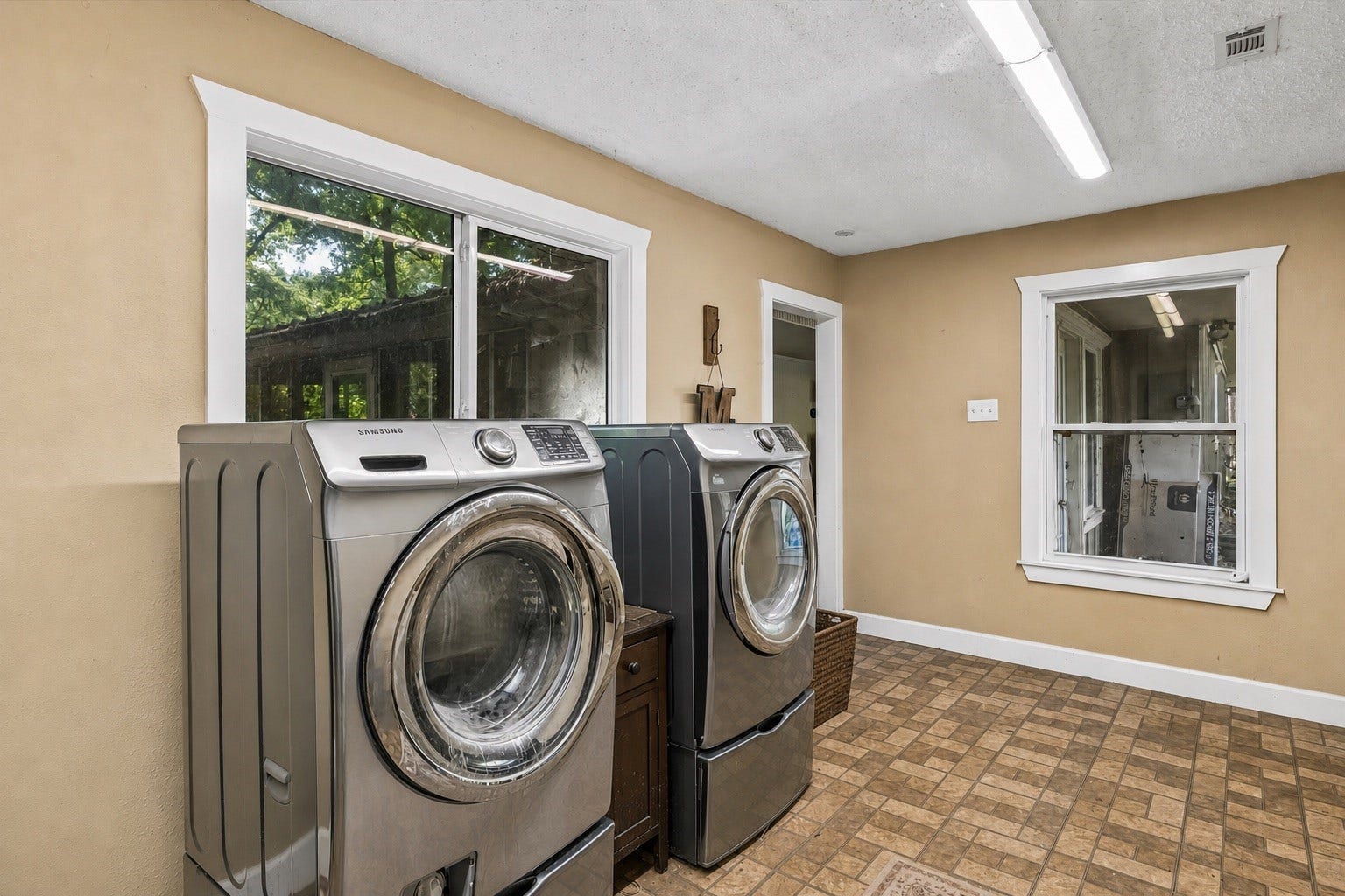 226 S Pine Drive, Montgomery, TX 77356 Two large windows brighten the laundry room and overlook the surrounding greenery. The generous floor area leaves space for sorting and folding beside the laundry pair.