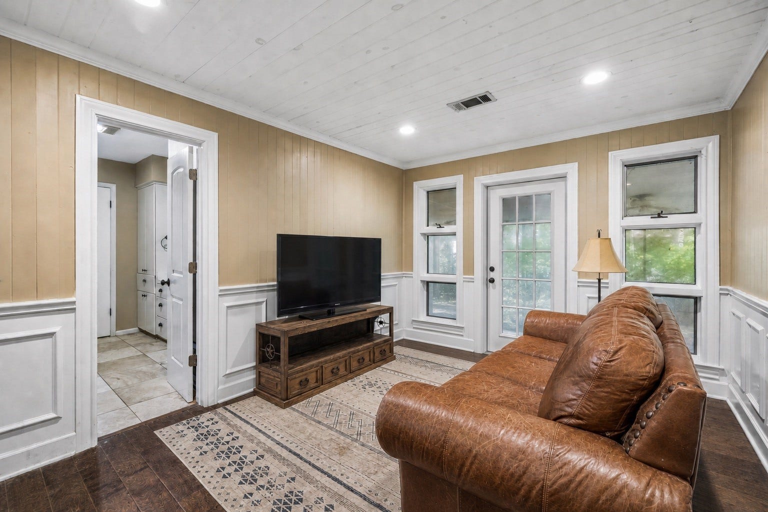 226 S Pine Drive, Montgomery, TX 77356 A glass-paneled exterior door and flanking windows brighten this intimate sitting area. Decorative wall paneling adds character to a comfortable spot for reading or watching a favorite show.