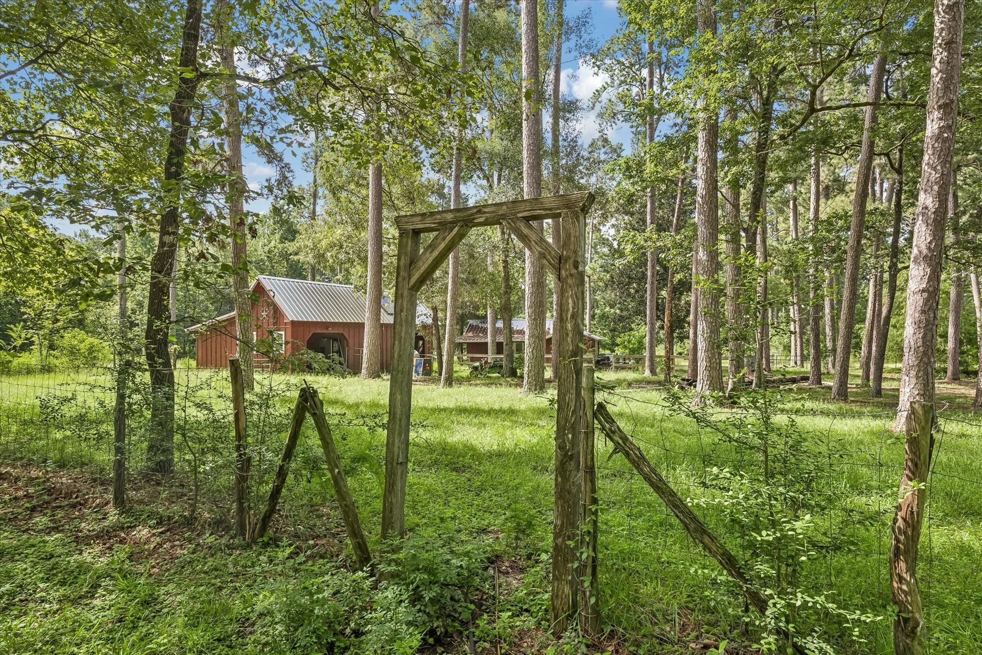 226 S Pine Drive, Montgomery, TX 77356 A timber-framed opening marks a rustic passage through the fenced grounds.