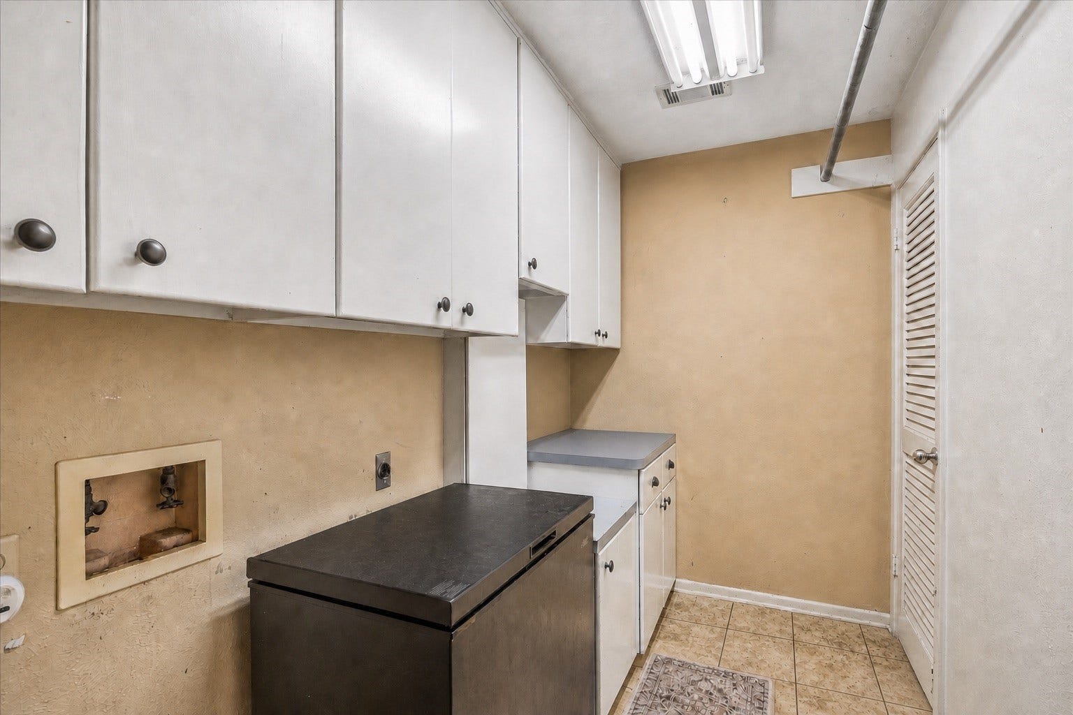 226 S Pine Drive, Montgomery, TX 77356 Overhead cabinets and a hanging rail organize the adjoining utility area. A separate counter creates a convenient surface for household projects and laundry preparation.
