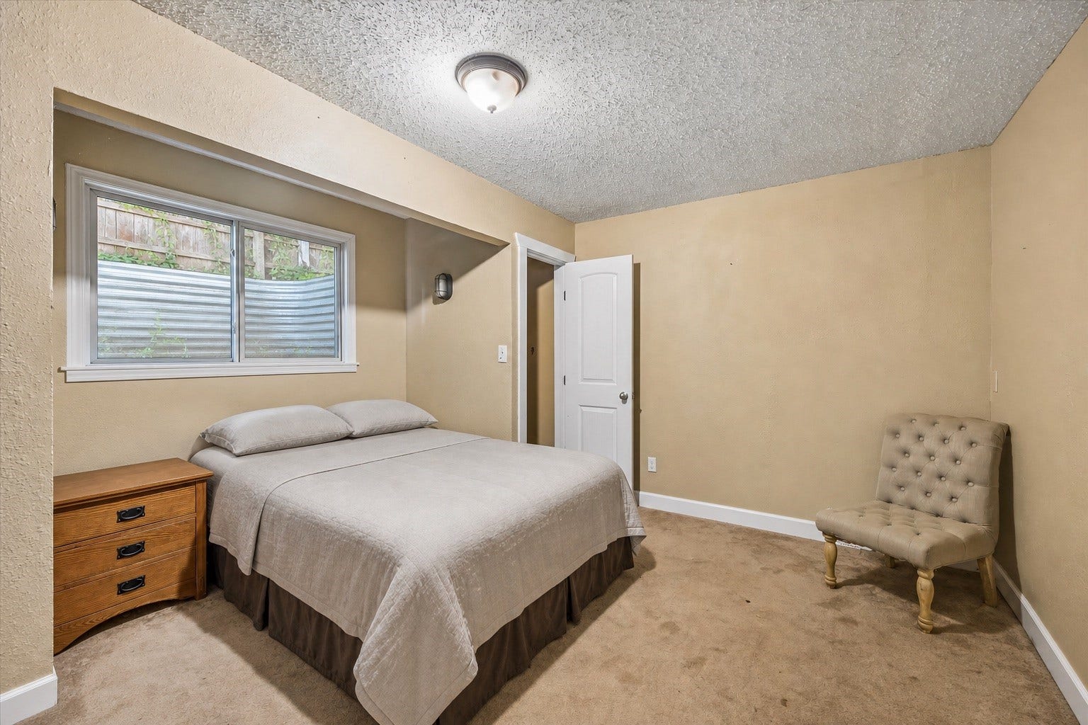 226 S Pine Drive, Montgomery, TX 77356 A recessed bed alcove gives this bedroom a cozy feel, with a horizontal window positioned above the headboard. Warm wall tones soften the space.
