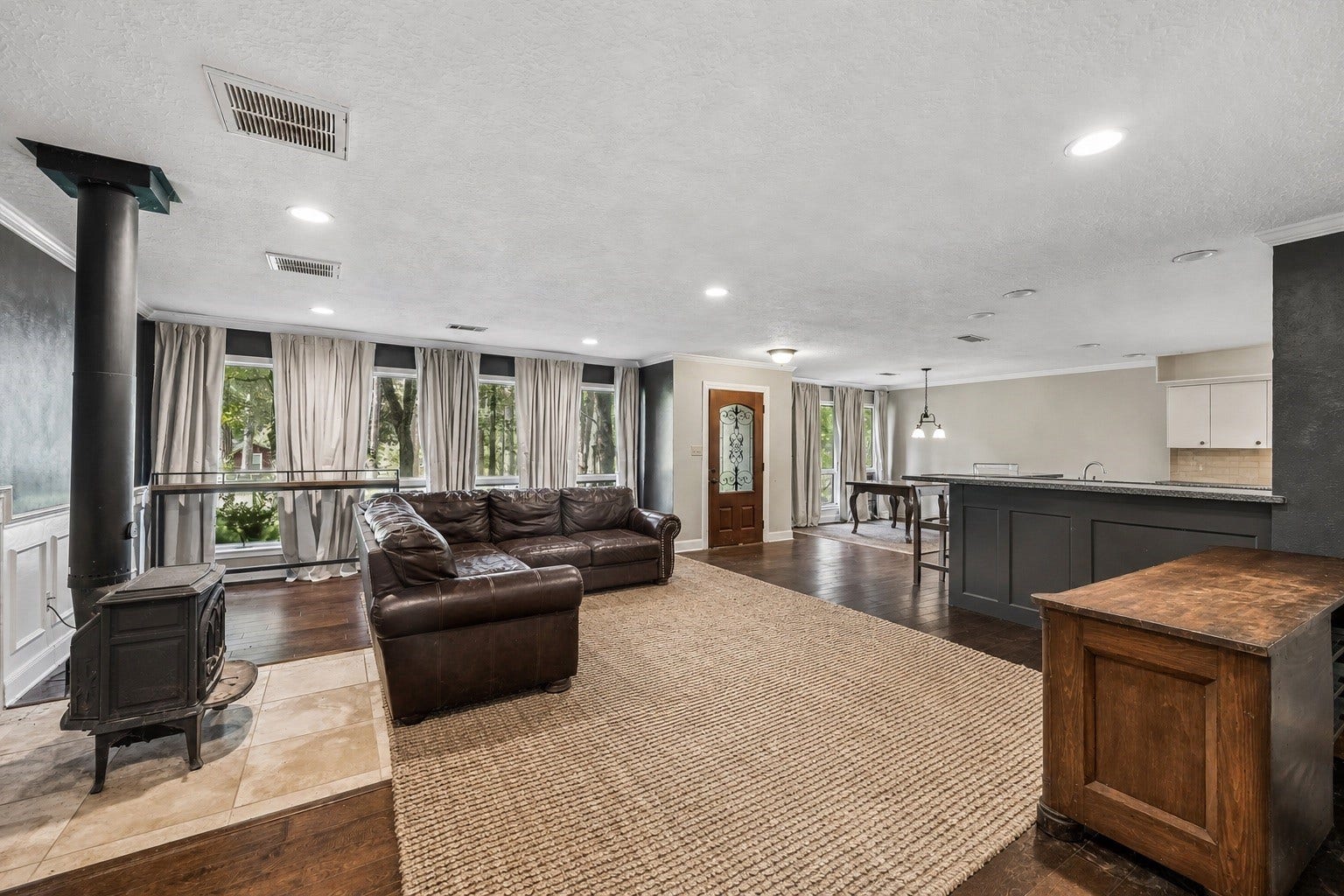 226 S Pine Drive, Montgomery, TX 77356 Gather around the freestanding stove on its tiled hearth, with the kitchens breakfast bar just beyond the seating area. The open connection keeps conversation flowing while meals come together.