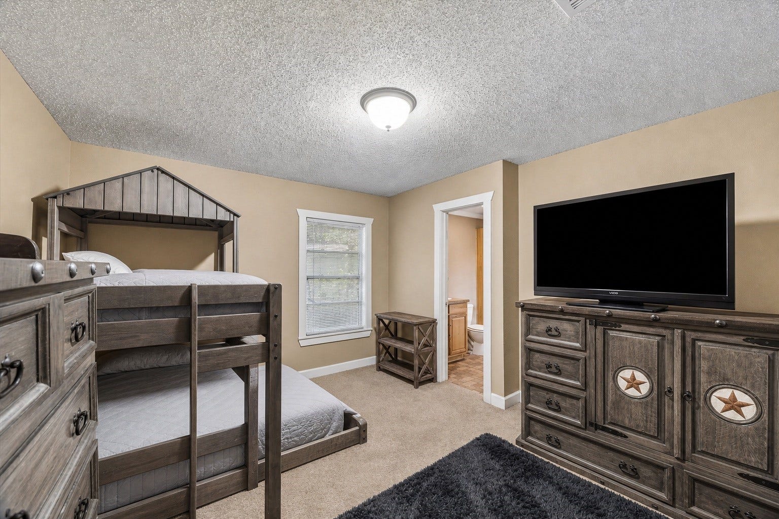 226 S Pine Drive, Montgomery, TX 77356 Shown with bunk beds, this bedroom offers a comfortable setting for shared sleeping arrangements. An open doorway connects directly to the adjoining bath.
