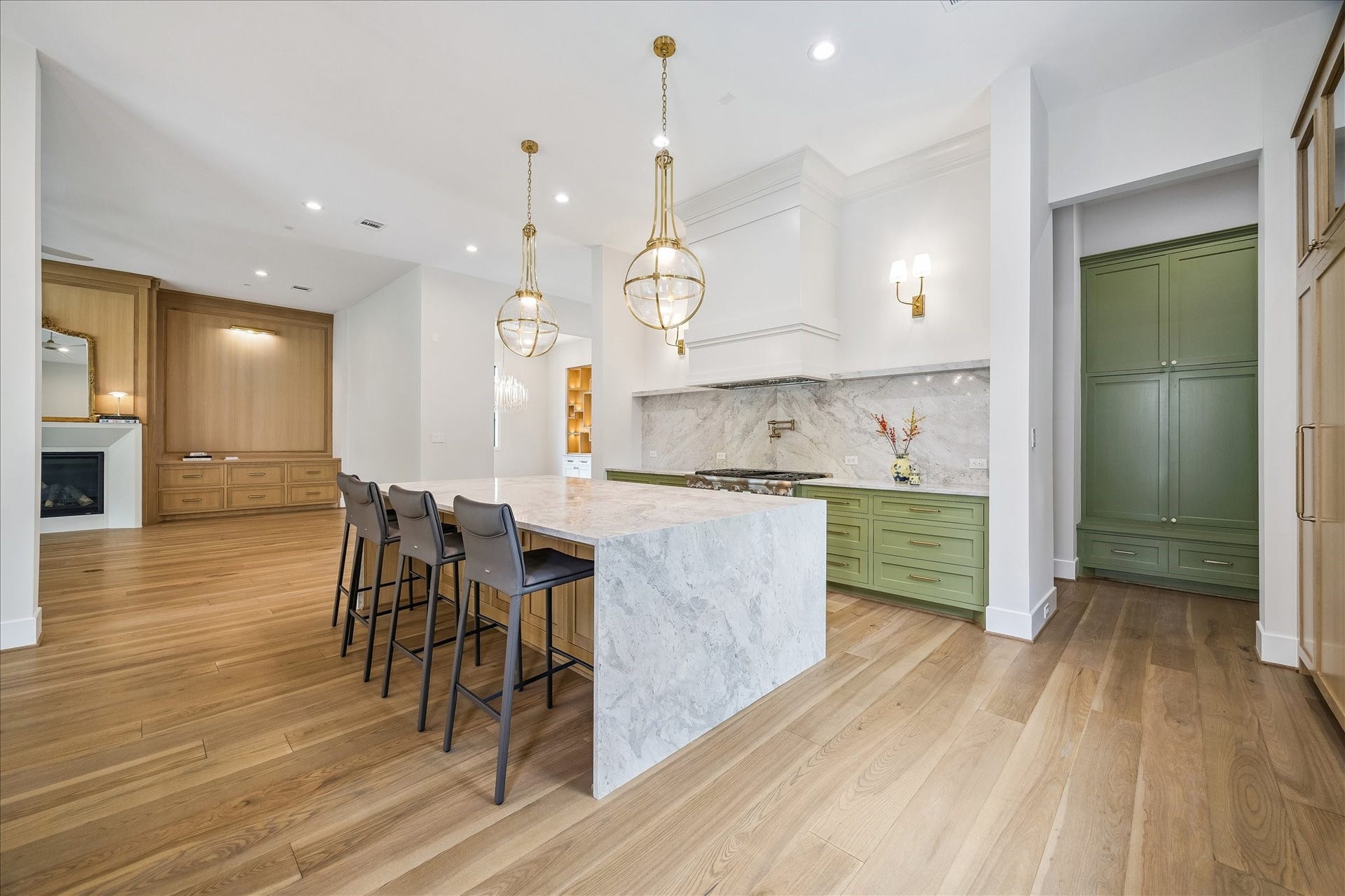 830 Azalea Street, Houston, TX 77018 This well-equipped kitchen is designed for both functionality and style, complete with a pot filler, custom vent hood, and elegant brass accents.
The cabinetry is a beautiful blend of white oak and painted finishes, enhanced with brass accents and soft-close hardware for a seamless look. A hidden walk-in pantry offers extensive storage, ensuring that everything is kept neatly organized and easily accessible. This thoughtful design provides both convenience and an uncluttered aesthetic.