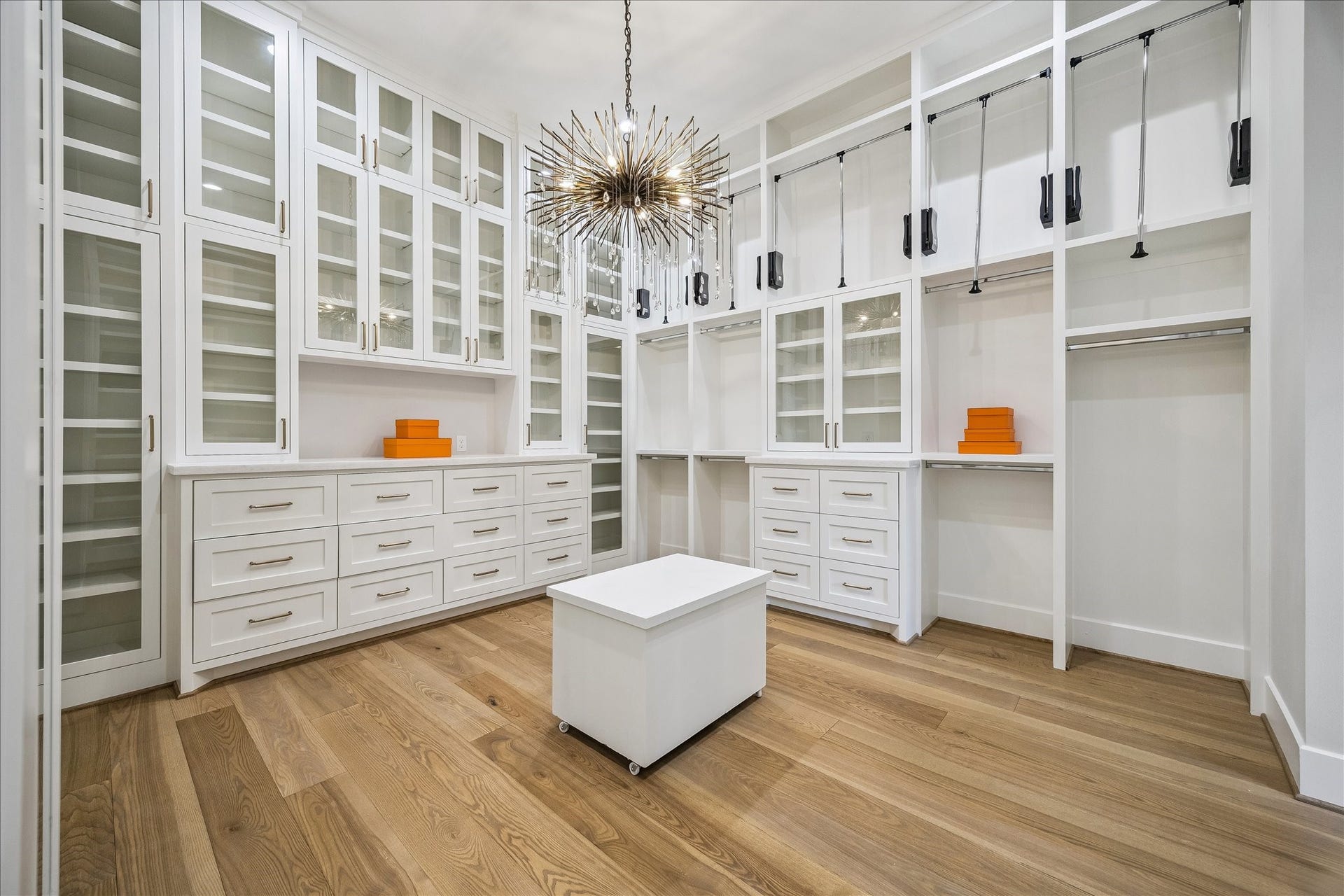 830 Azalea Street, Houston, TX 77018 The custom wardrobe system is designed for maximum organization and includes glass-front cabinetry, built-in dresser towers, pull-down hanging racks, and abundant shelving and drawers.
