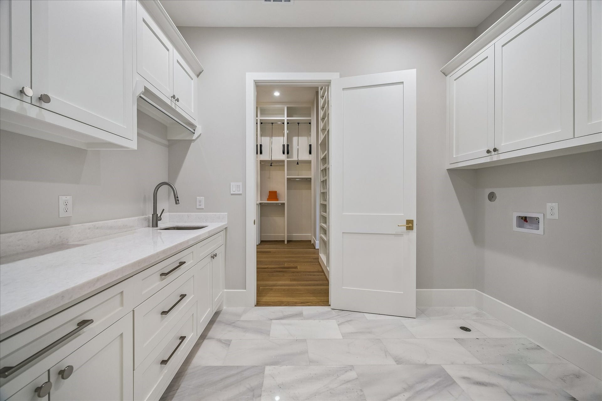 830 Azalea Street, Houston, TX 77018 Ideally situated on the upper level, this thoughtfully designed laundry suite offers the ultimate in daily convenience with dual-access doors from both the main hallway and the primary bedroom. Designed to streamline your routine, the space features premium quartz countertops for effortless folding, high-end cabinetry, and a deep built-in utility sink.