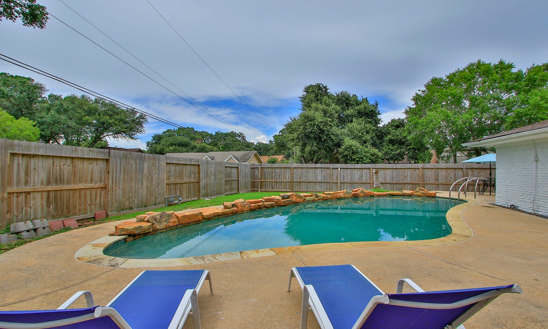 207 Burgundy Lane, League City, TX 77573 The charming, ample backyard, with a curved pool and covered porch is a focal point for entertainment.
