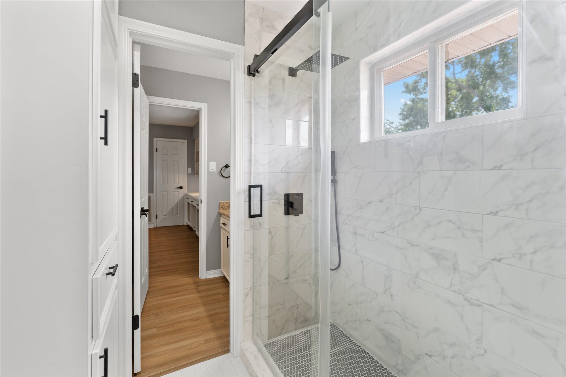 207 Burgundy Lane, League City, TX 77573 The secondary bathroom features a luxurious glass-enclosed shower with marble-style tiles and a rain showerhead.