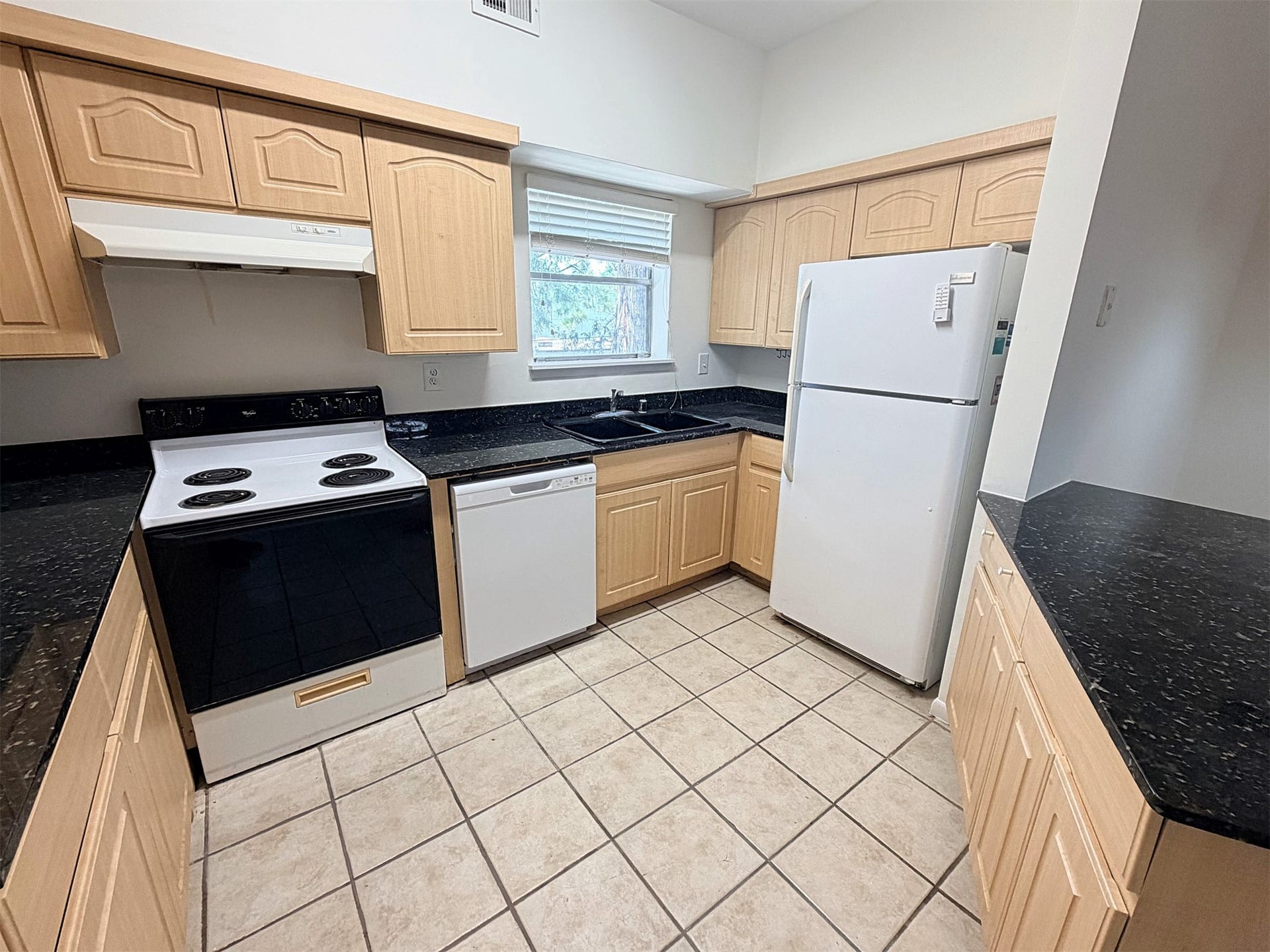 The kitchen features tile flooring, an electric range, dishwasher, and full size refrigerator