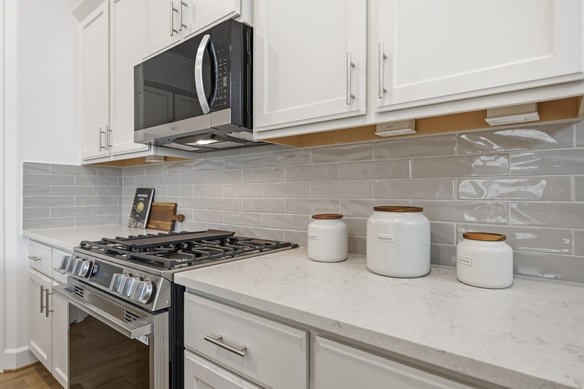 5405 Nolda Street, Houston, TX 77007 Timeless Functionality: The heart of the home shines with a single-bay undermount sink, sleek gooseneck faucet, and polished quartz countertopspaired with custom cabinets adorned with elegant hardware for a refined yet functional touch.