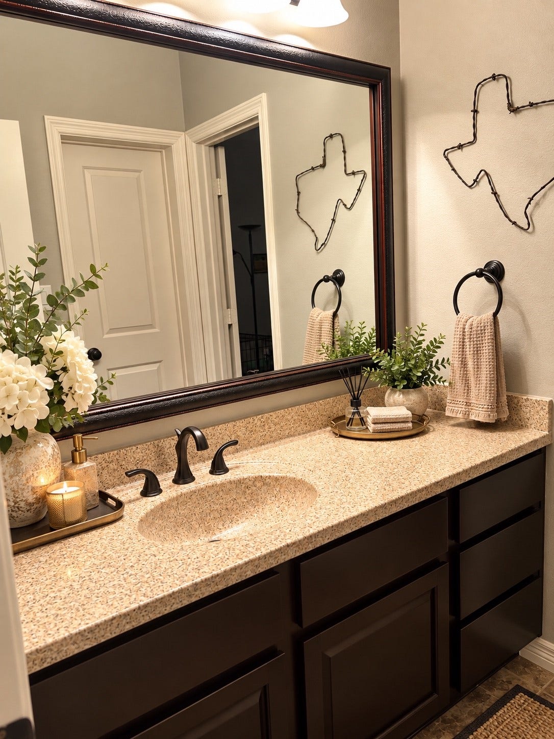 6902 Ladera Lane, Missouri City, TX 77459 Inviting full guest bath offers a quartz vanity, rich dark cabinetry, framed mirror, coordinating bronze fixtures and plenty of counter and storage space. Neutral finishes provide a warm, timeless look.