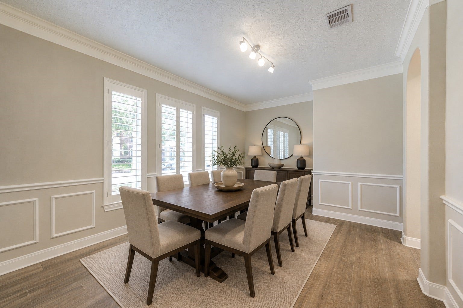 12806 Rock Falls Way, Houston, TX 77041 Elegant dining room with modern lighting, chair rail accents, and classic plantation shuttersideal for entertaining.
