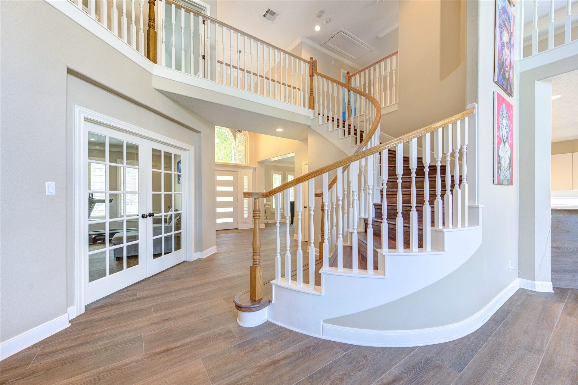 12806 Rock Falls Way, Houston, TX 77041 Elegant entryway with a grand curved staircase and stylish wood-like tile flooring.