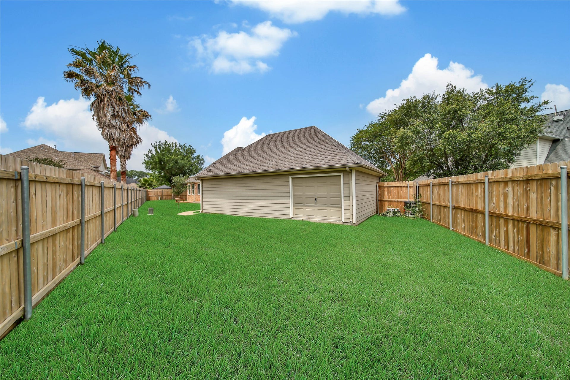 Drive through on 3rd bay of garage into an expansive section of the backyard.