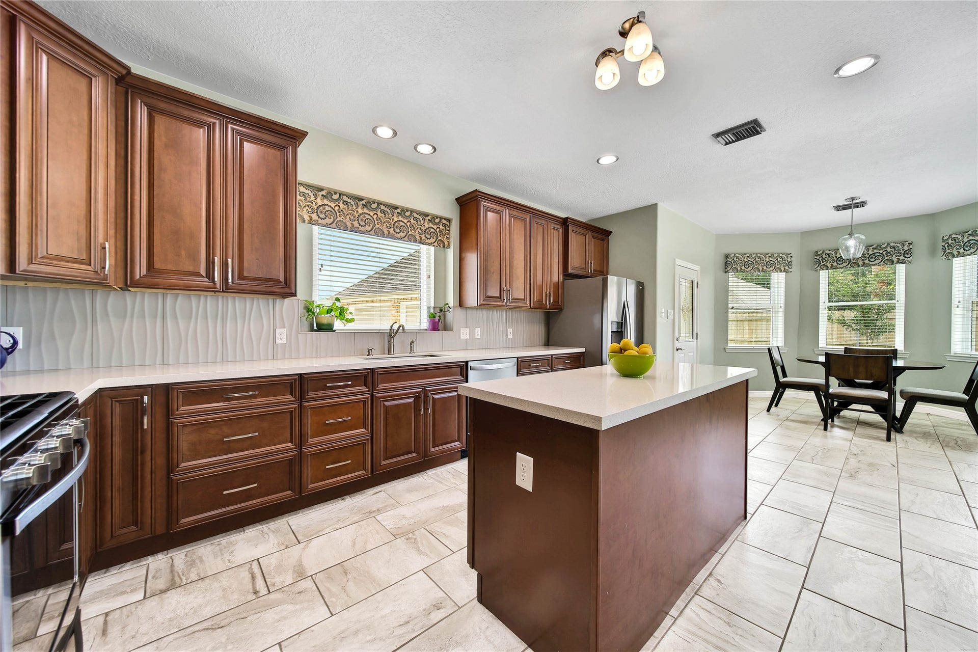 Kitchen island offers functional prep and utility to this kitchen. Seller kept down draft in place under island for a future cooktop if desired.