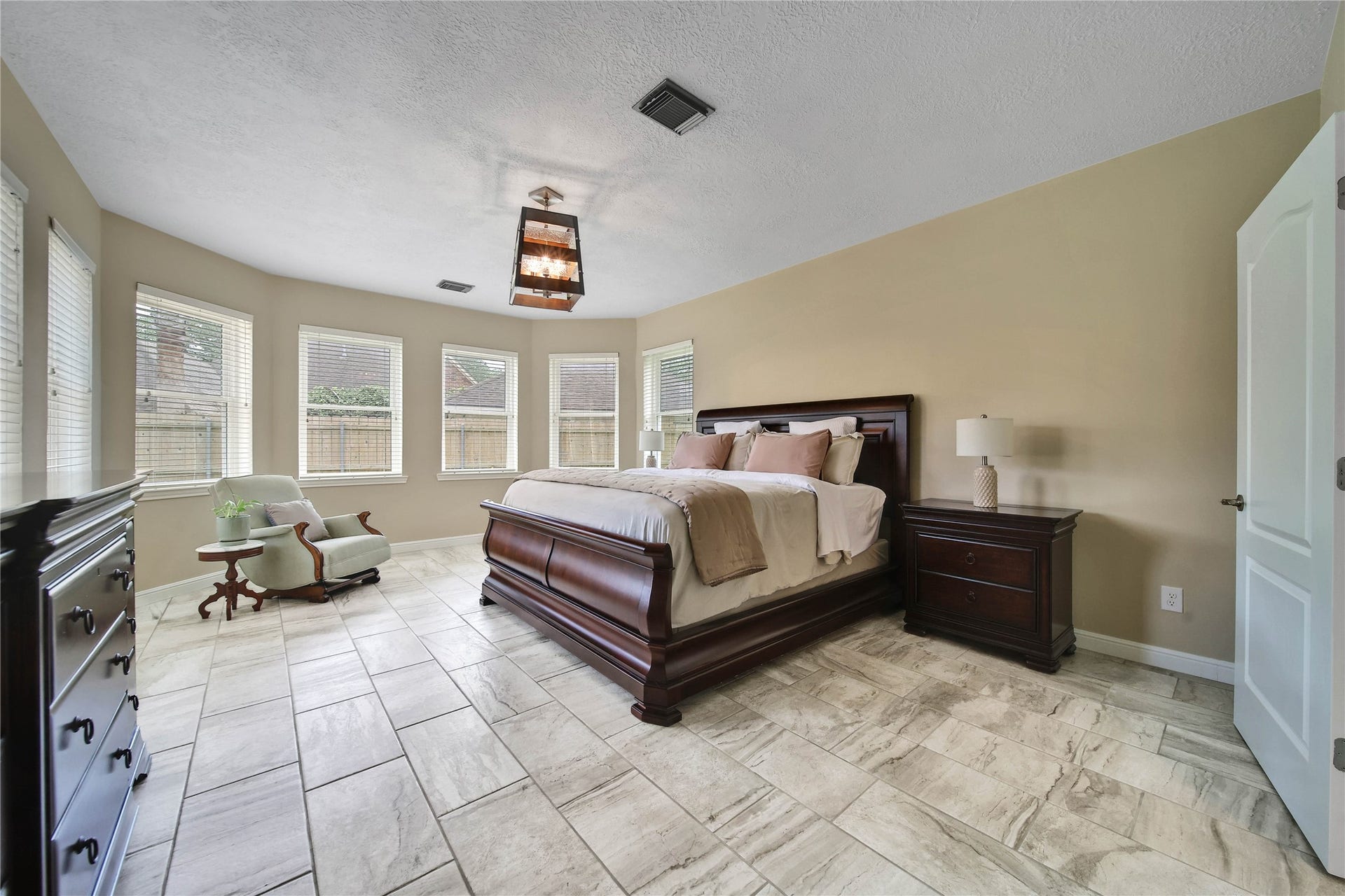 Primary bedroom has beautiful views and surrounded with windows. Beautiful tile floor continues through the main floor. Primary is large enough for a sitting area and can accommodate your larger furniture pieces.