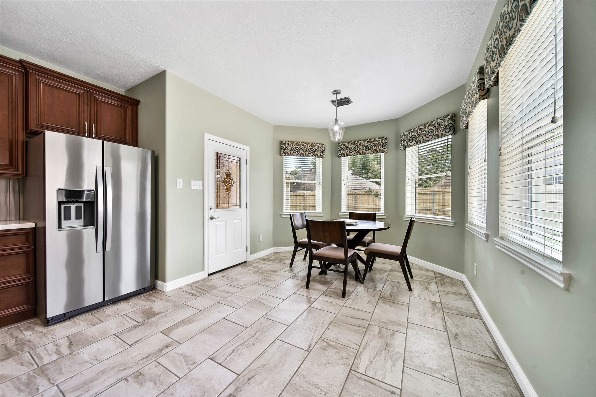 Spacious breakfast room with bright windows overlooking the backyard. Elegant window treatments make a designer statements.