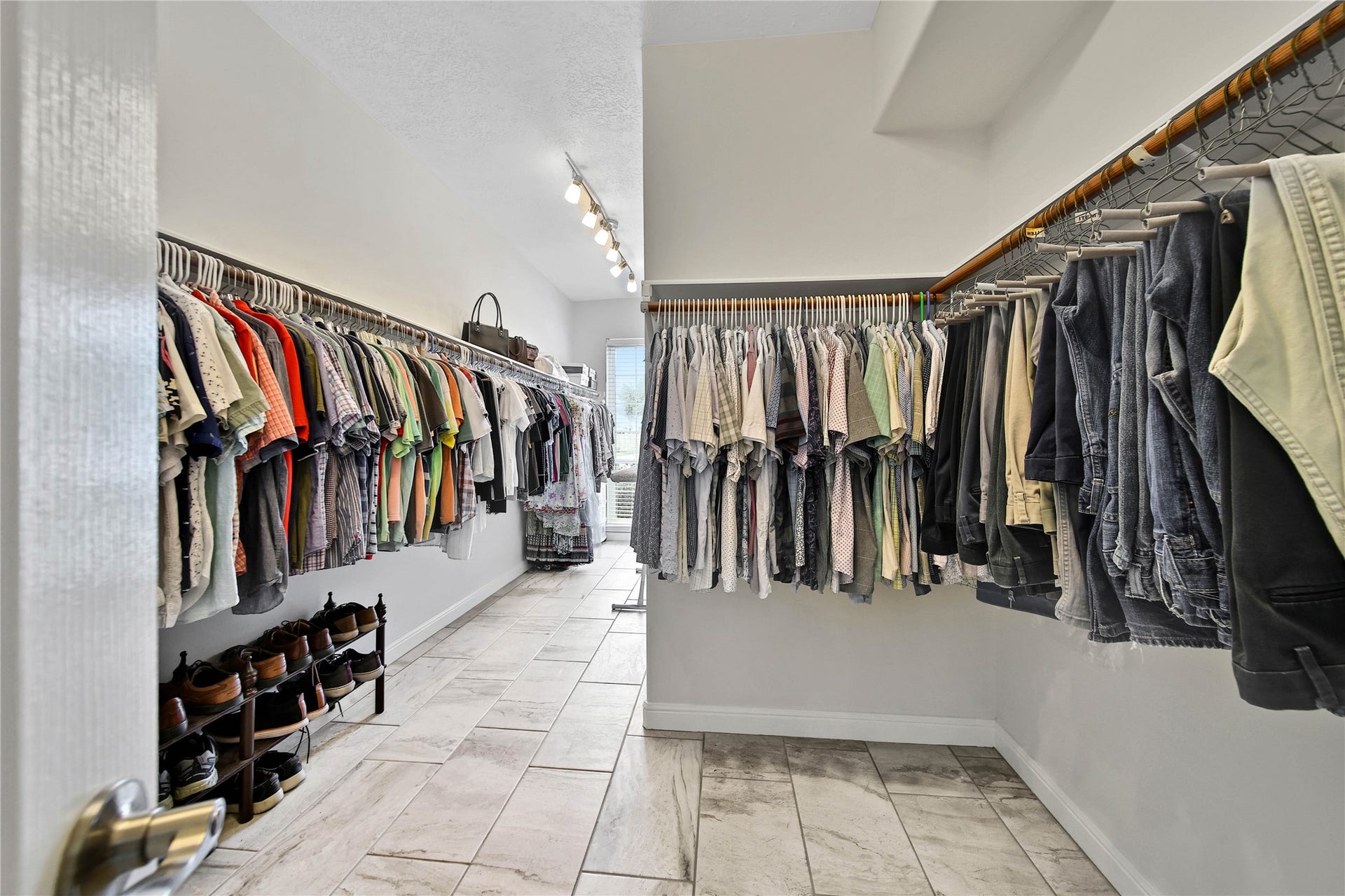 This HUGE primary closet and dressing room is located off the en-suite bath in the primary bedroom. SOOO much room in here!