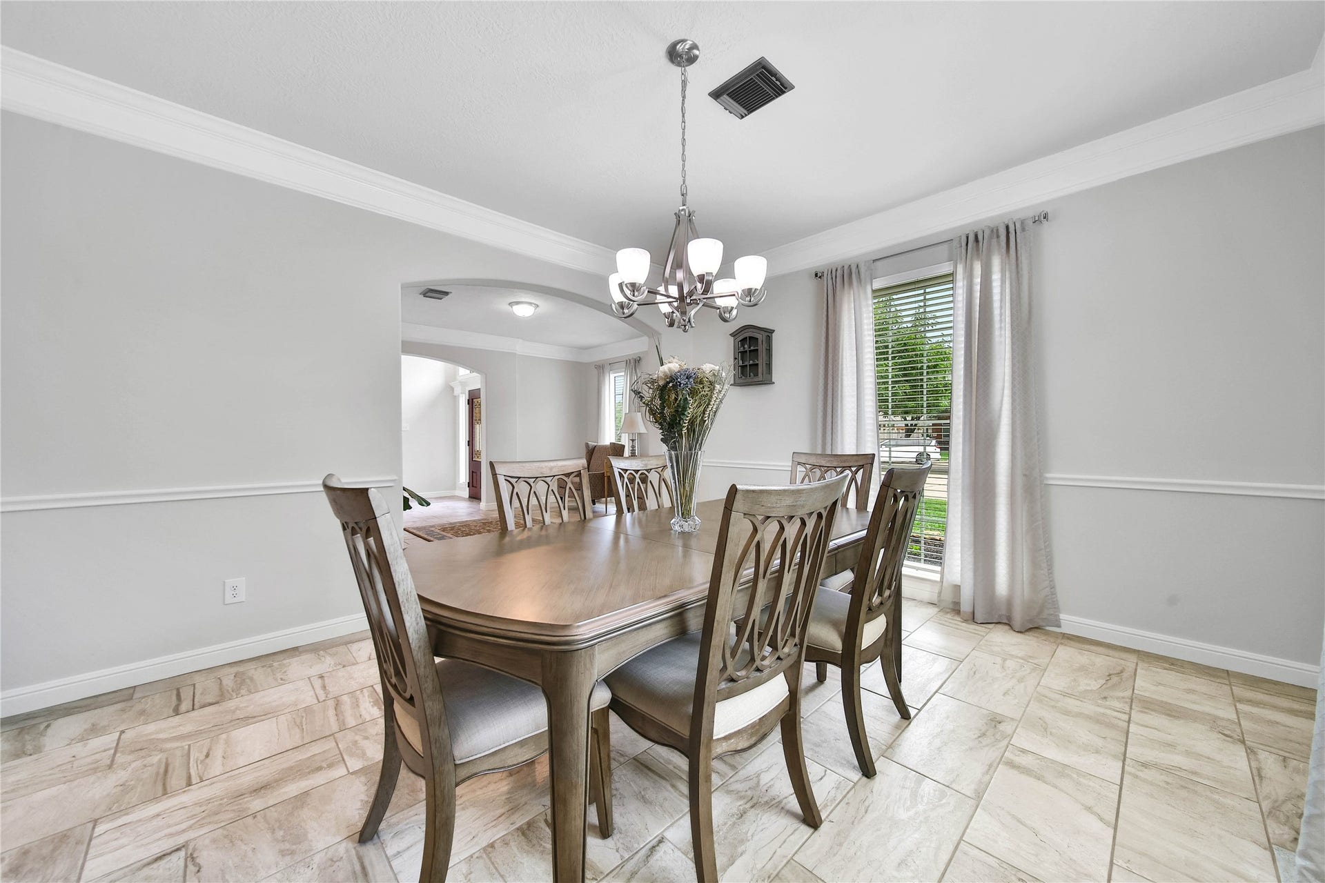 The elegant dining room overlooks the front yard and is adjacent to the formal / flex. Beautiful continuous tile floors throughout the main floor.