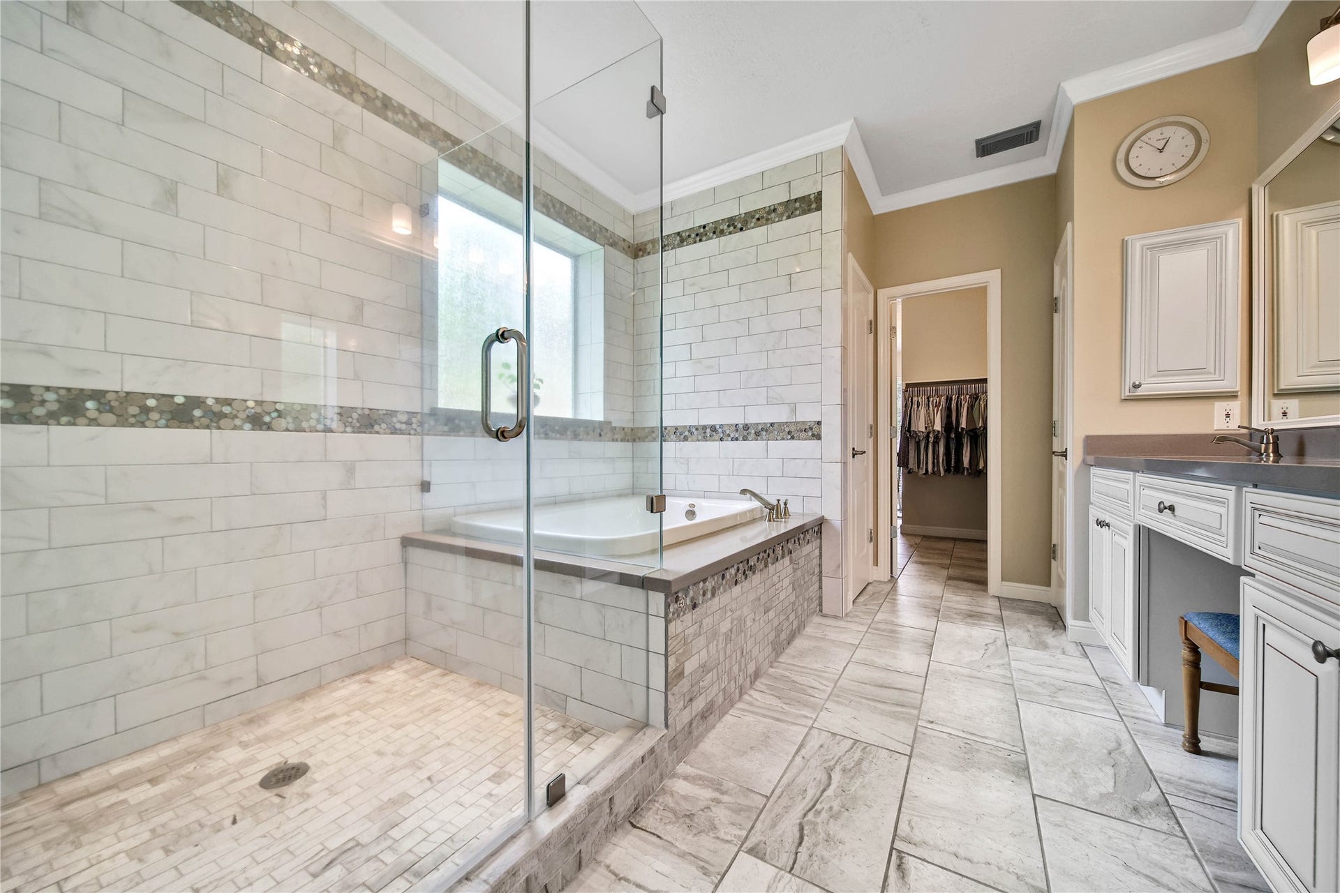 Enjoy gorgeous designer tile and finishes, oversize shower with seamless glass surround and soaker tub for relaxing!