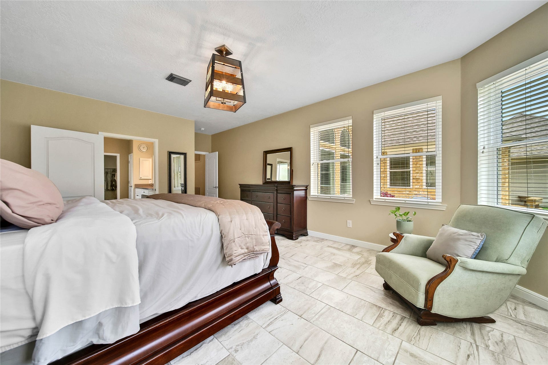 Primary bedroom has beautiful views and surrounded with windows. Beautiful tile floor continues through the main floor. Primary is large enough for a sitting area and can accommodate your larger furniture pieces.