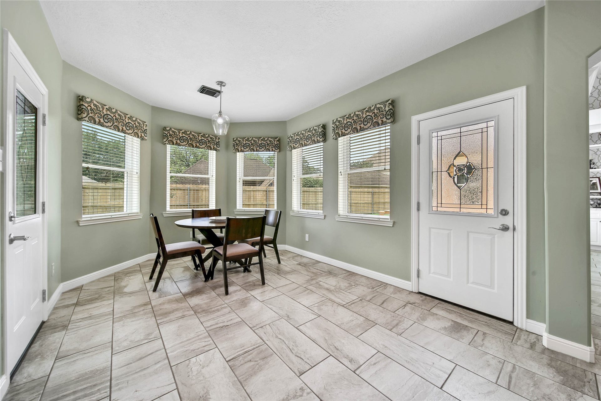 Spacious breakfast room with bright windows overlooking the backyard. Elegant window treatments make a designer statements.