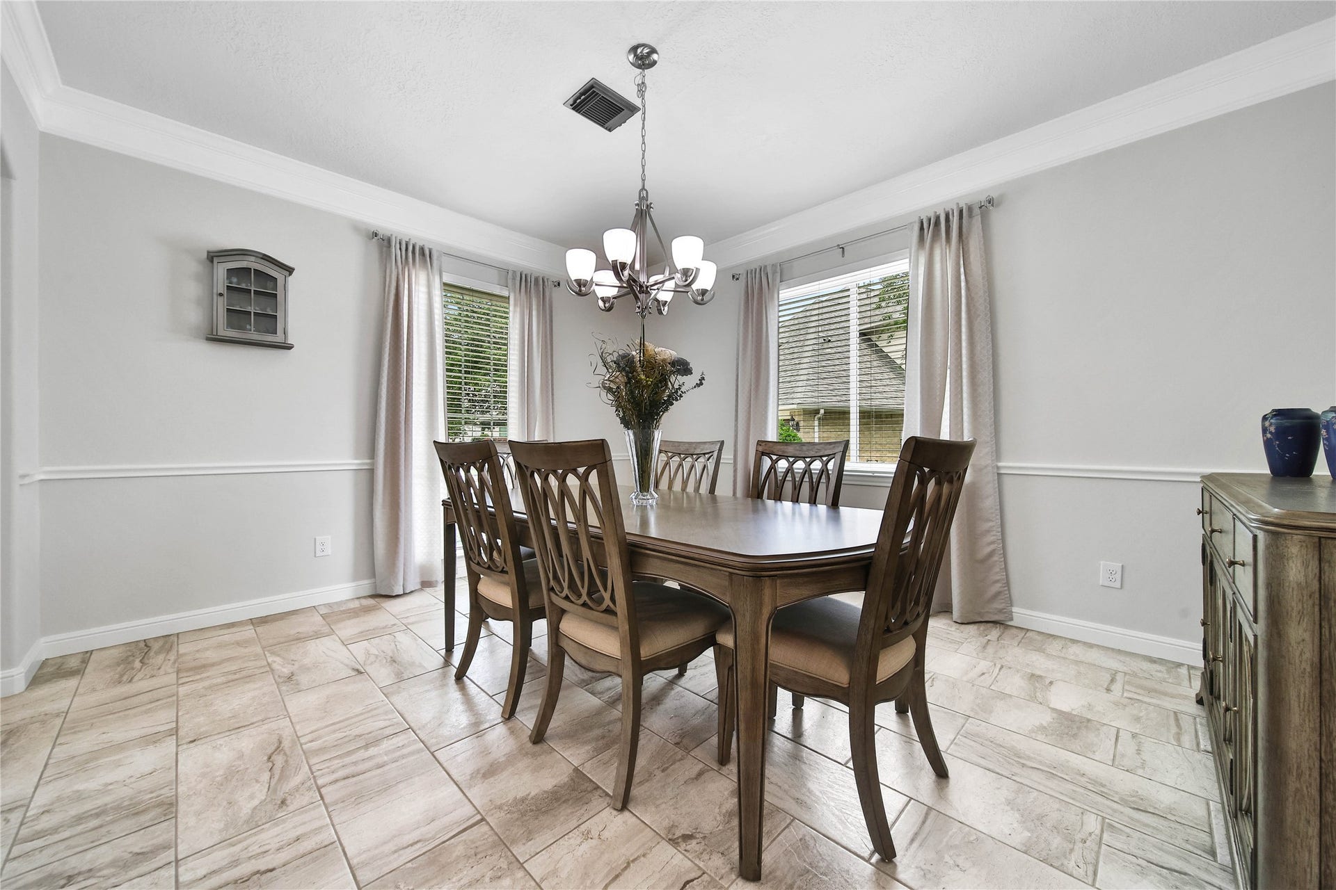 Bright Sunny windows flank two walls in this elegant dining room.