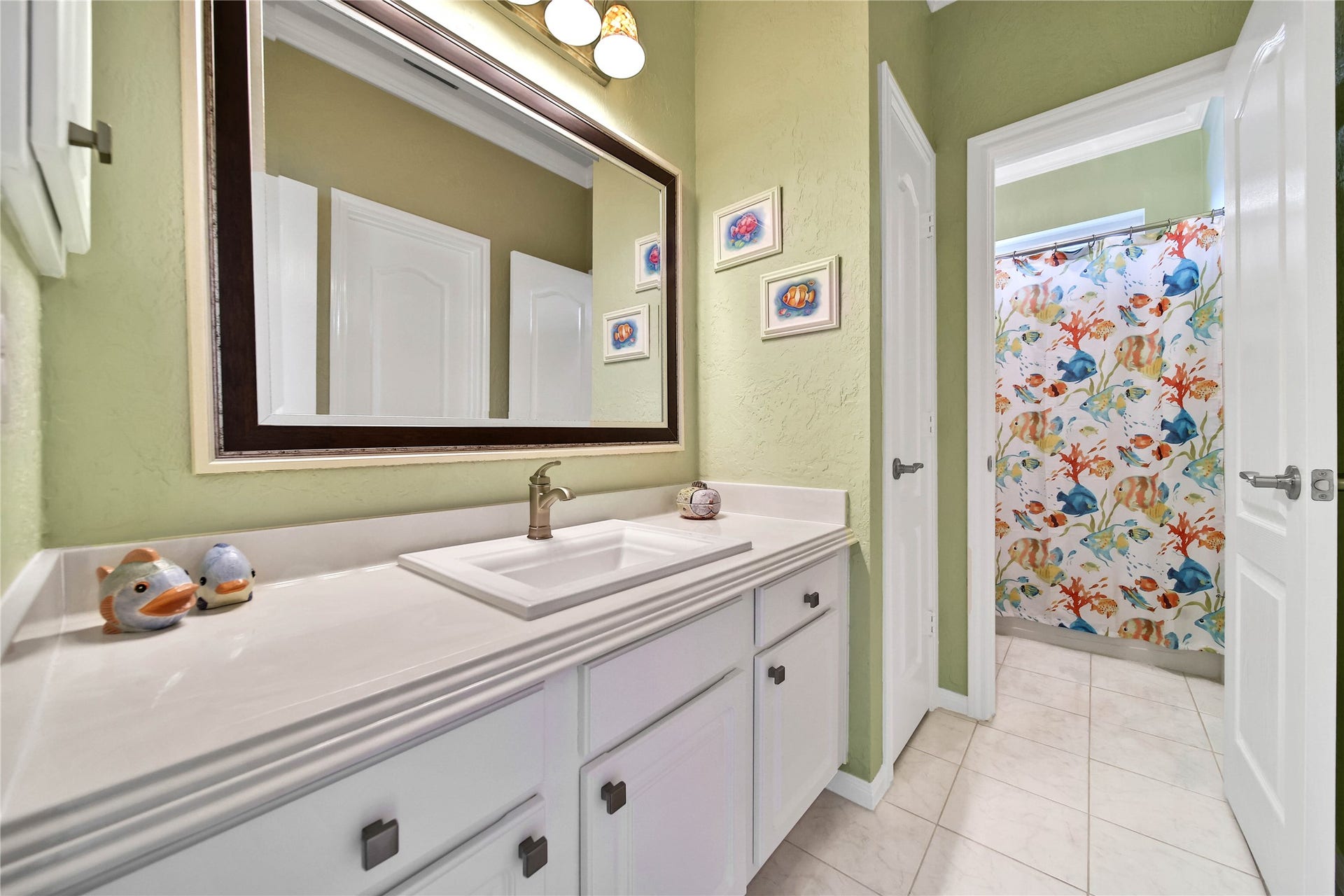 Large secondary bath upstairs with spacious waterfall countertop and lots of storage. Custom sink and updated hardware, framed in mirror elevate this secondary bath.