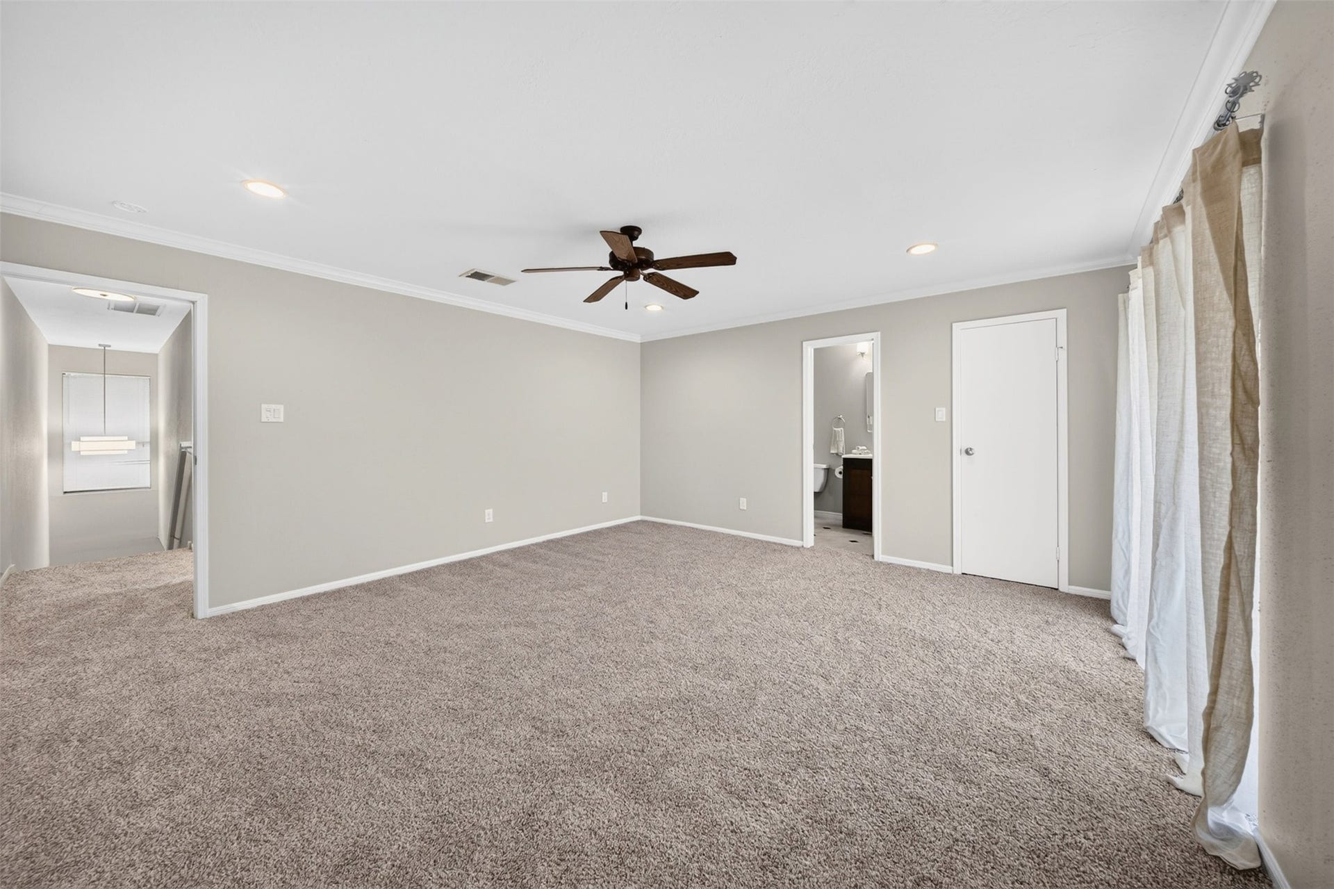 2379 Briarwest Boulevard, #85, Houston, TX 77077 Another angle of the second bedroom: sheer-curtained windows, a ceiling fan, and doorways to the ensuite bath and closet.