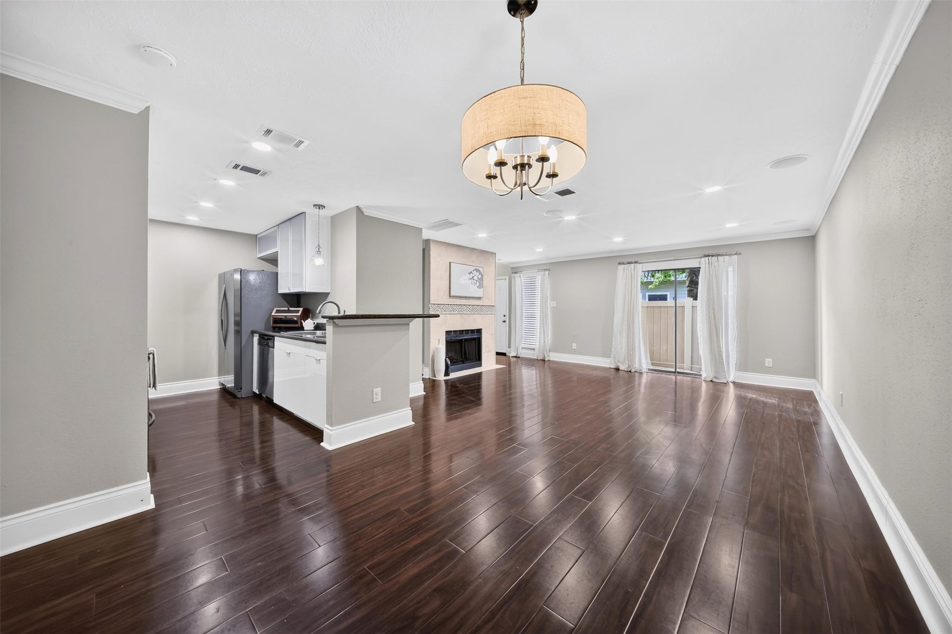2379 Briarwest Boulevard, #85, Houston, TX 77077 The dining nook pairs dark wood floors and crown molding with a fabric drum chandelier sized for a full table with room to spare.