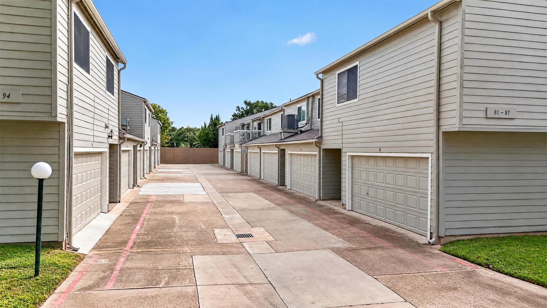 2379 Briarwest Boulevard, #85, Houston, TX 77077 View down the rear garage alley, showing the attached two-car garages serving each townhome.