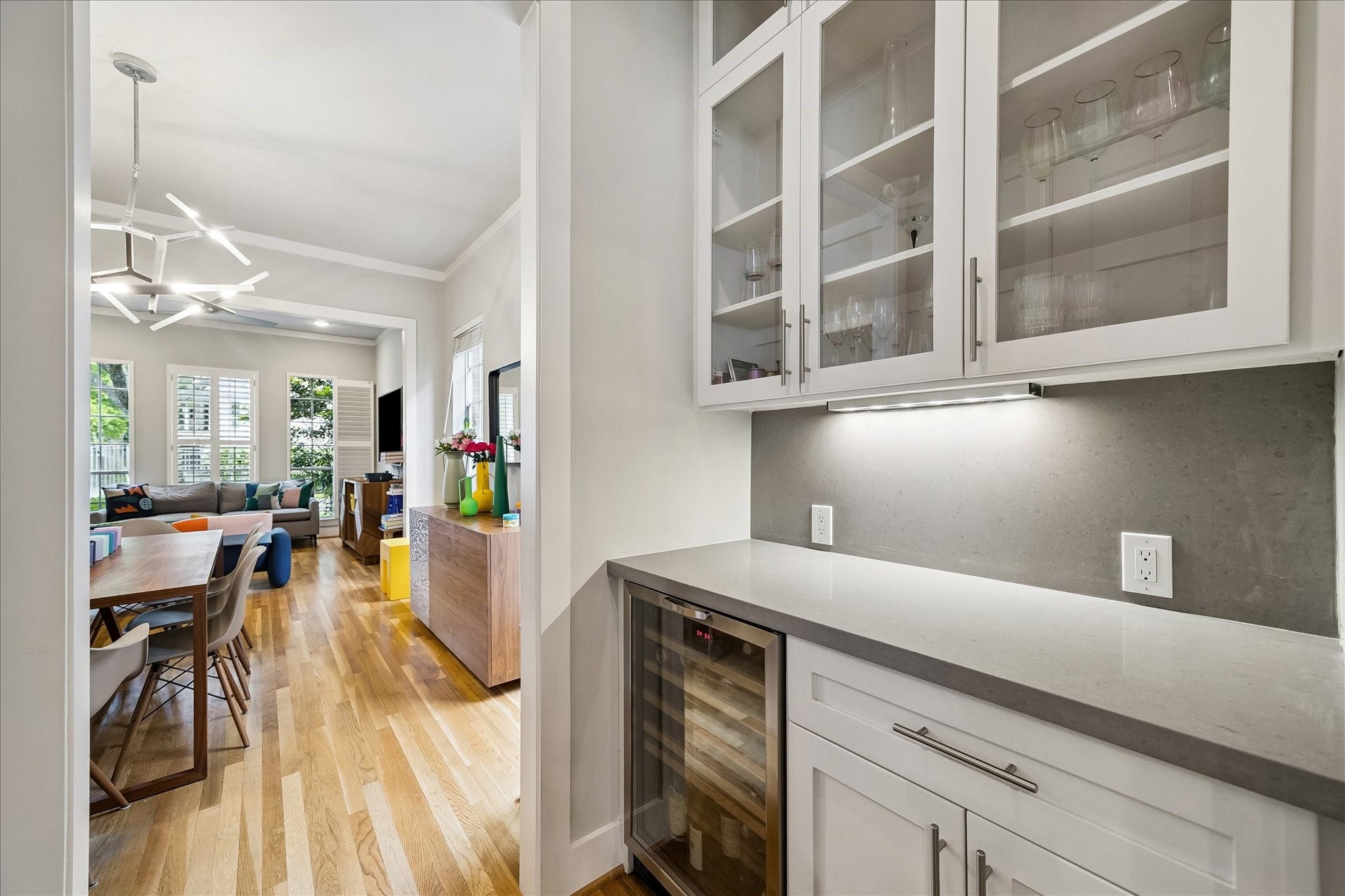 The butler's pantry continues the quartz counters and also features and undercounter beverage refrigerator coupled with glass front upper cabinets.