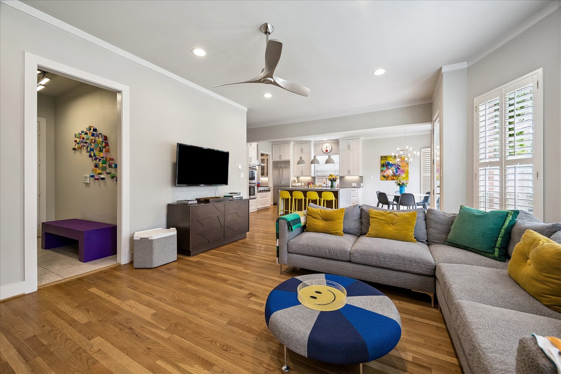 Here, the living room is captured in the foreground with the kitchen and breakfast area seen in the background.  To the left is the mud room and pedestrian door to the attached garage.