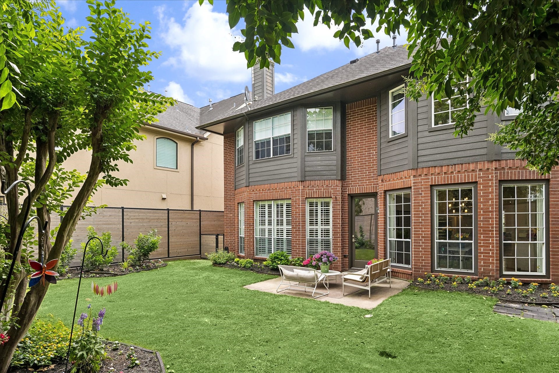 Another view of the backyard with a wall of windows along the first floor.