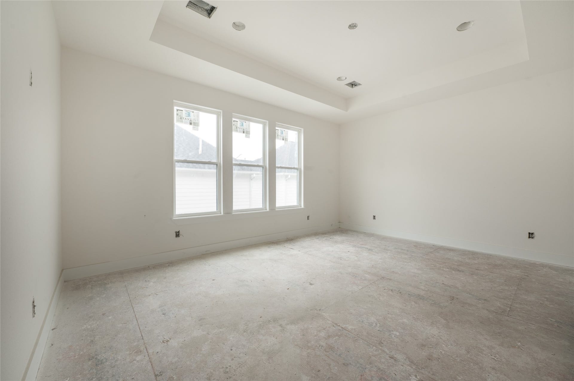 Primary bedroom with double deck ceilings and large windows
