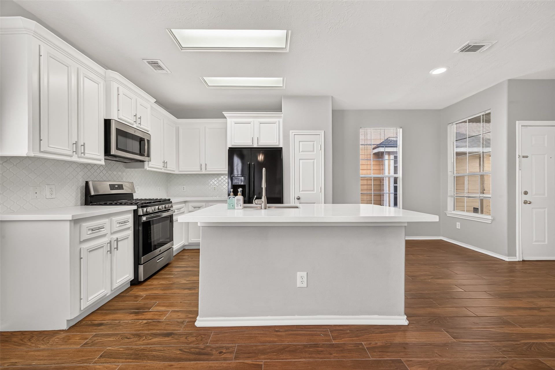 8734 Thistlemoor Lane, Houston, TX 77044 Completely renovated kitchen with white cabinets, beautiful backsplash and quartz countertops