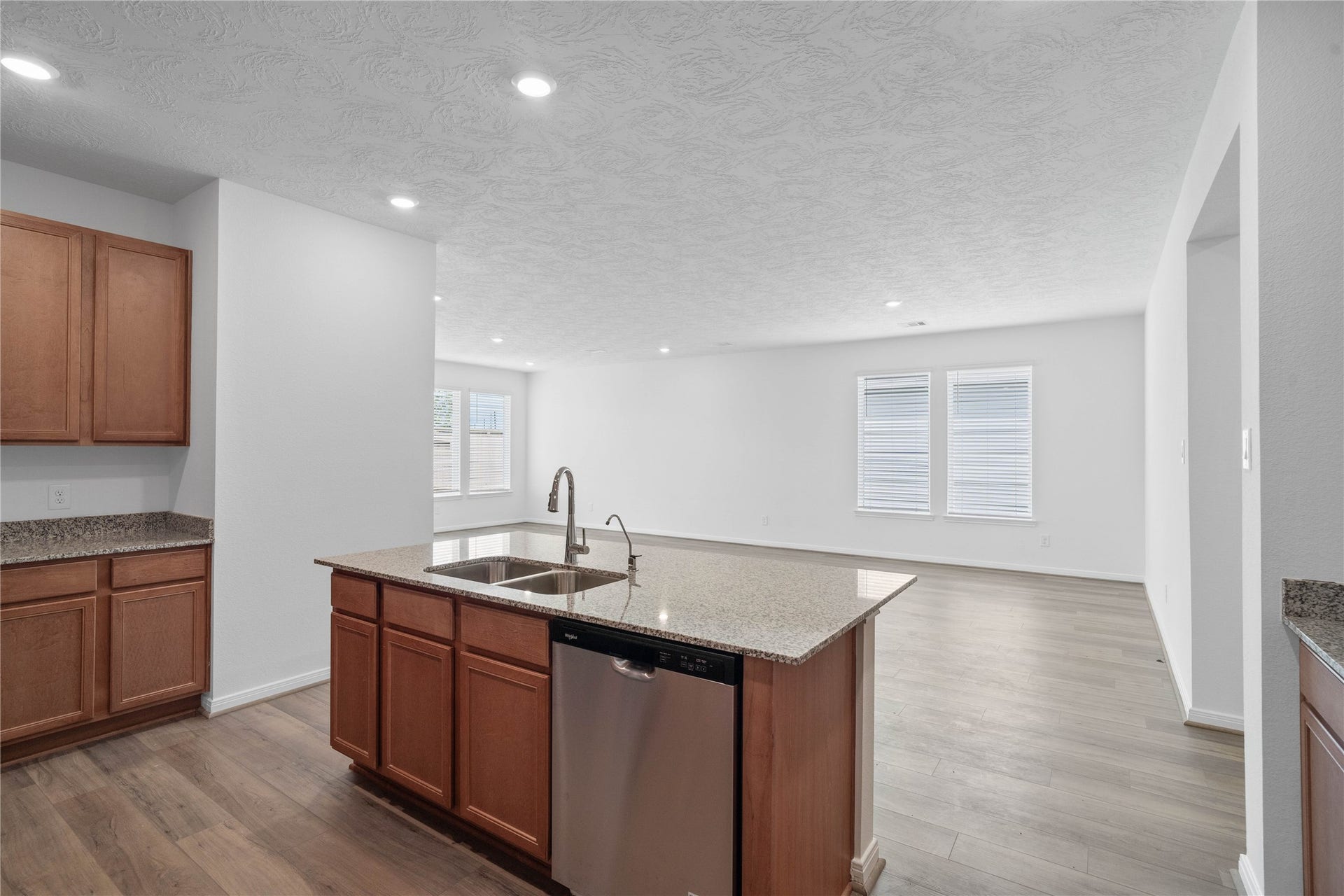 Featured here is the gorgeous granite countertops and the view looking out to the open concept living spaces and backyard views!