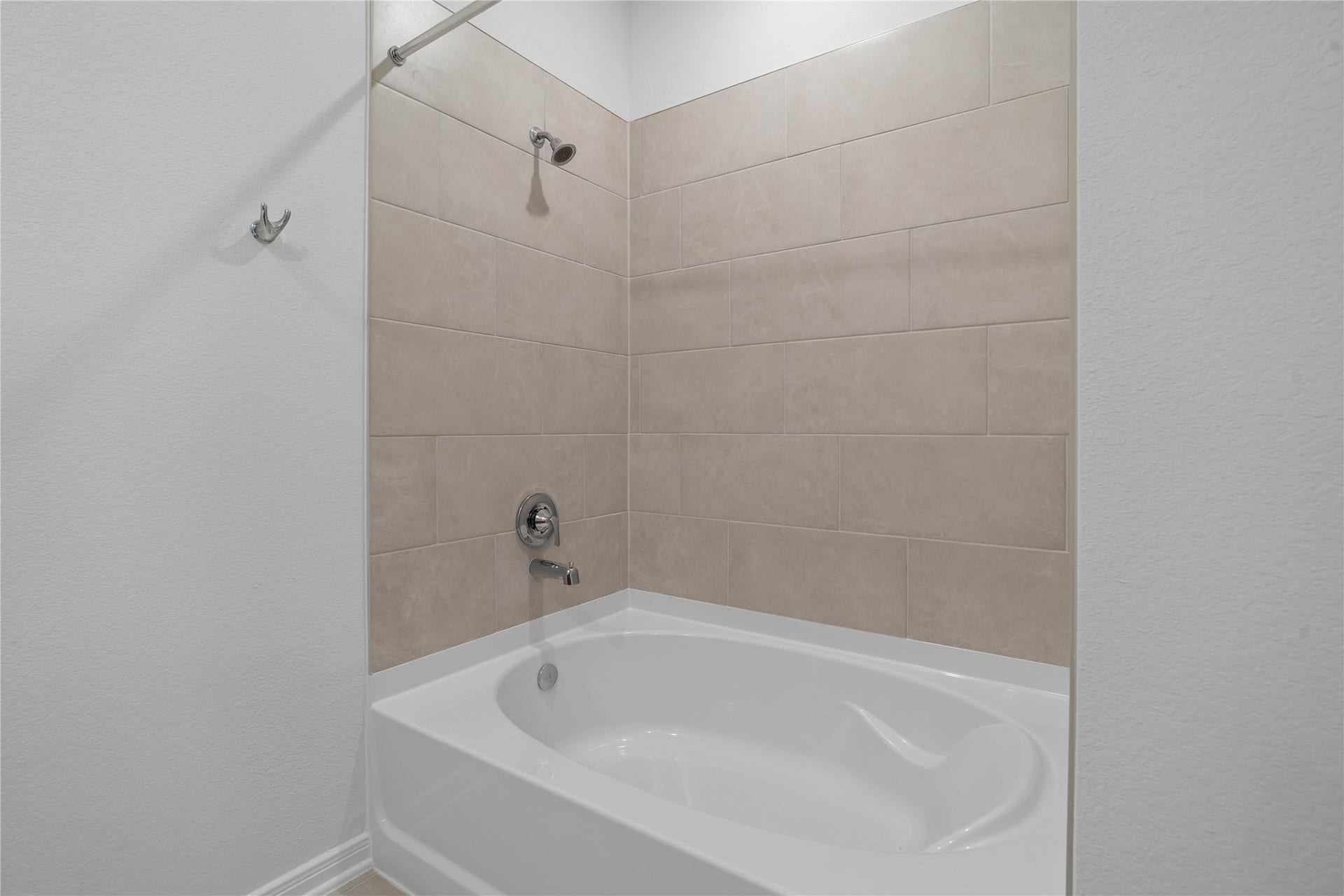 Primary bath features a large tub and shower combination with tile surround.