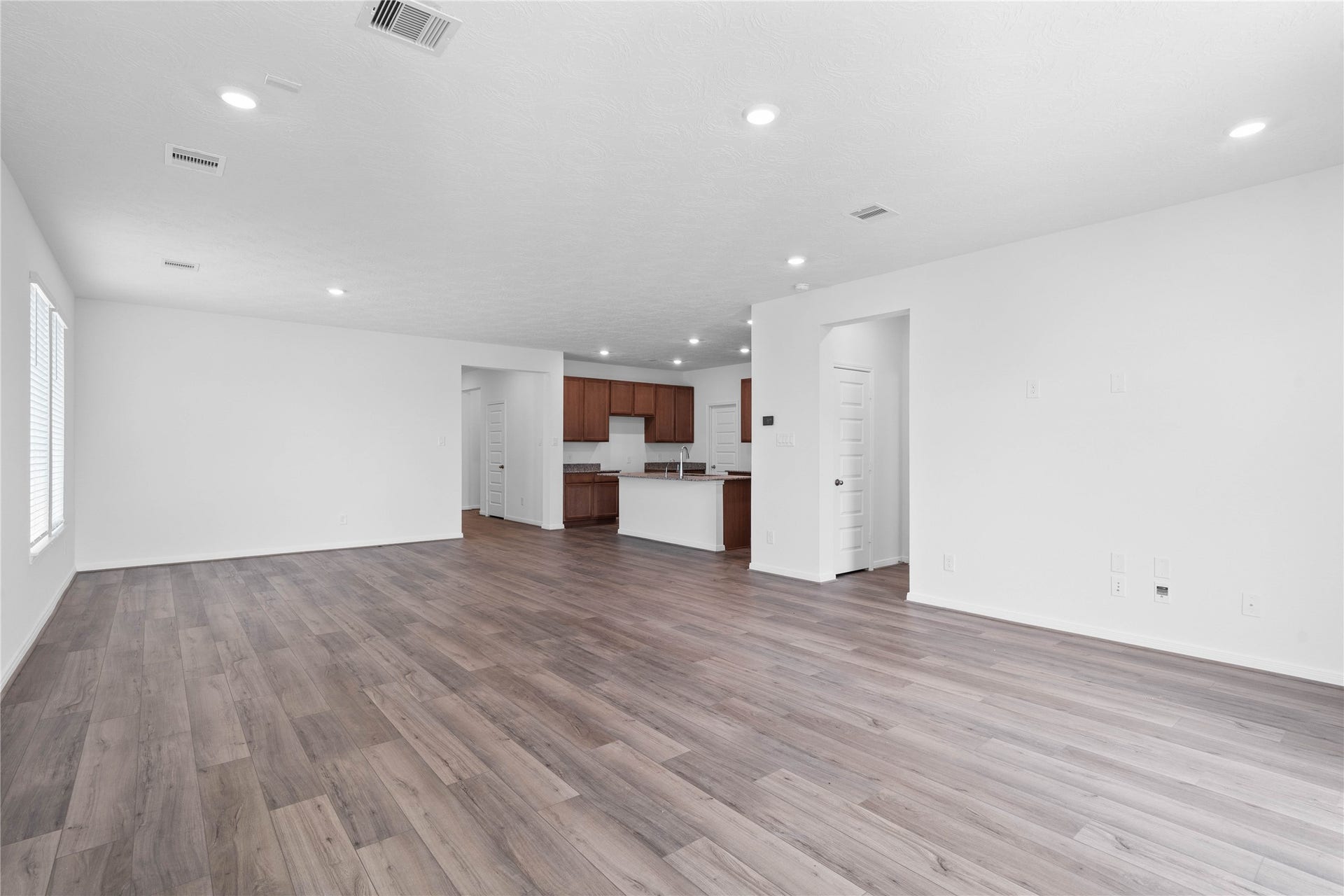 View from the Family Room into the kitchen and hallway towards the secondary bedrooms and entryway. Primary bedroom entrance seen here on the right.